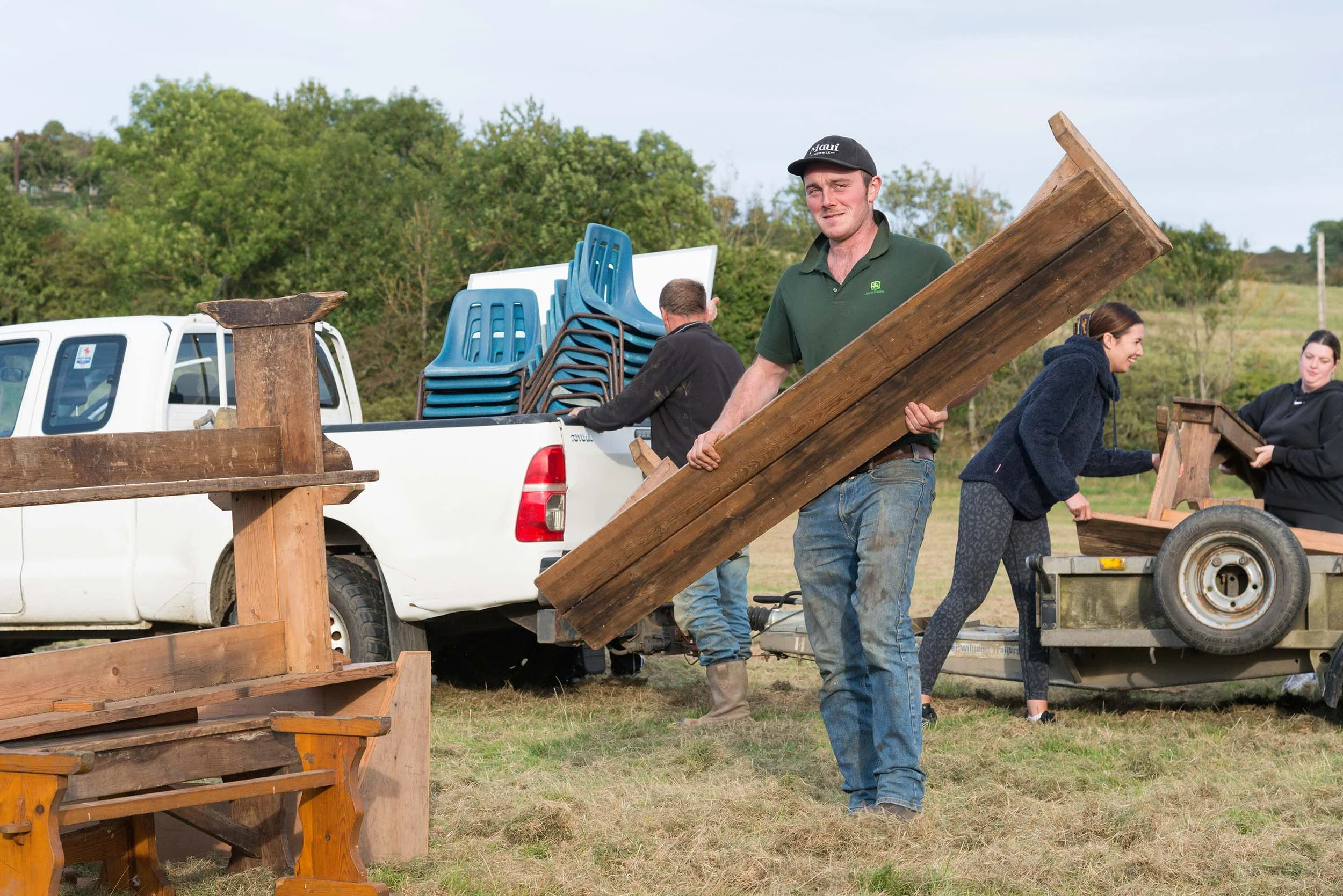 An image of a coquetdale young farmer helping in setting up Thropton Show by unloading benches on a warm late summers evening
