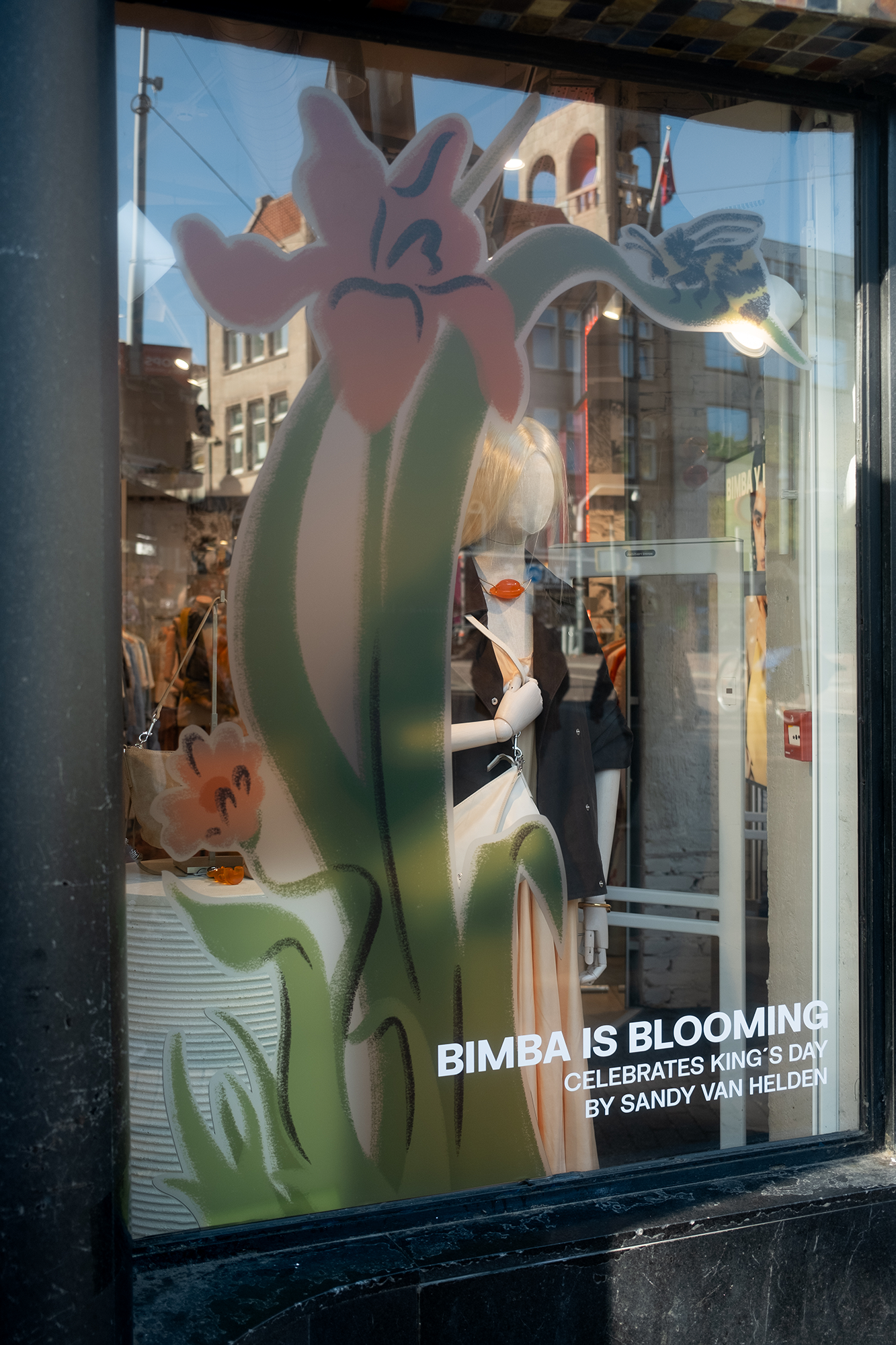 Sandy van Helden window display illustration installed at Bimba Y Lola Amsterdam store — flowers and grass
