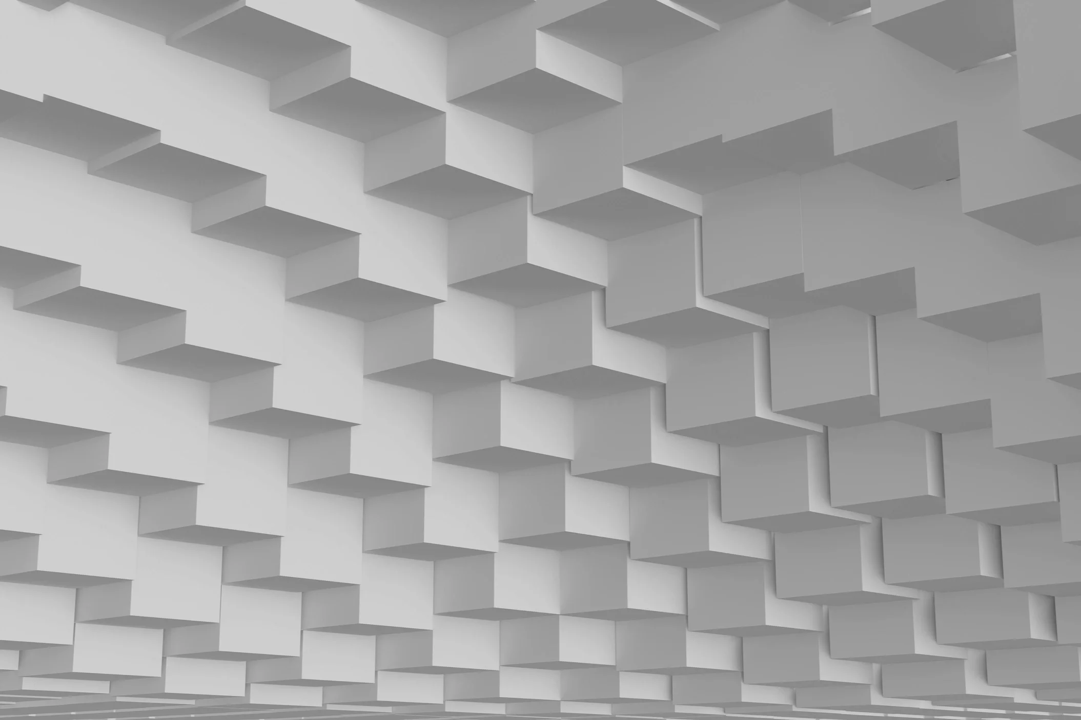 A ceiling with white geometric 3D square panel designs creating a pattern of shadows and depth.