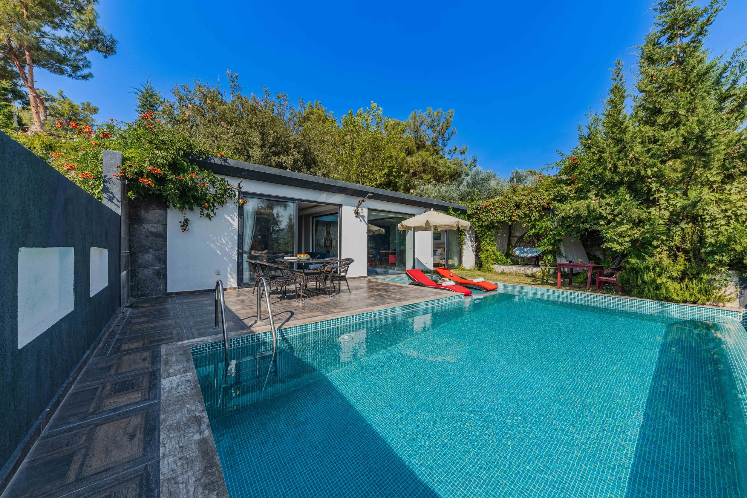 Moderne Poolanlage mit Natursteinumrandung und Holzdeck in einem Garten in Frankfurt am Main