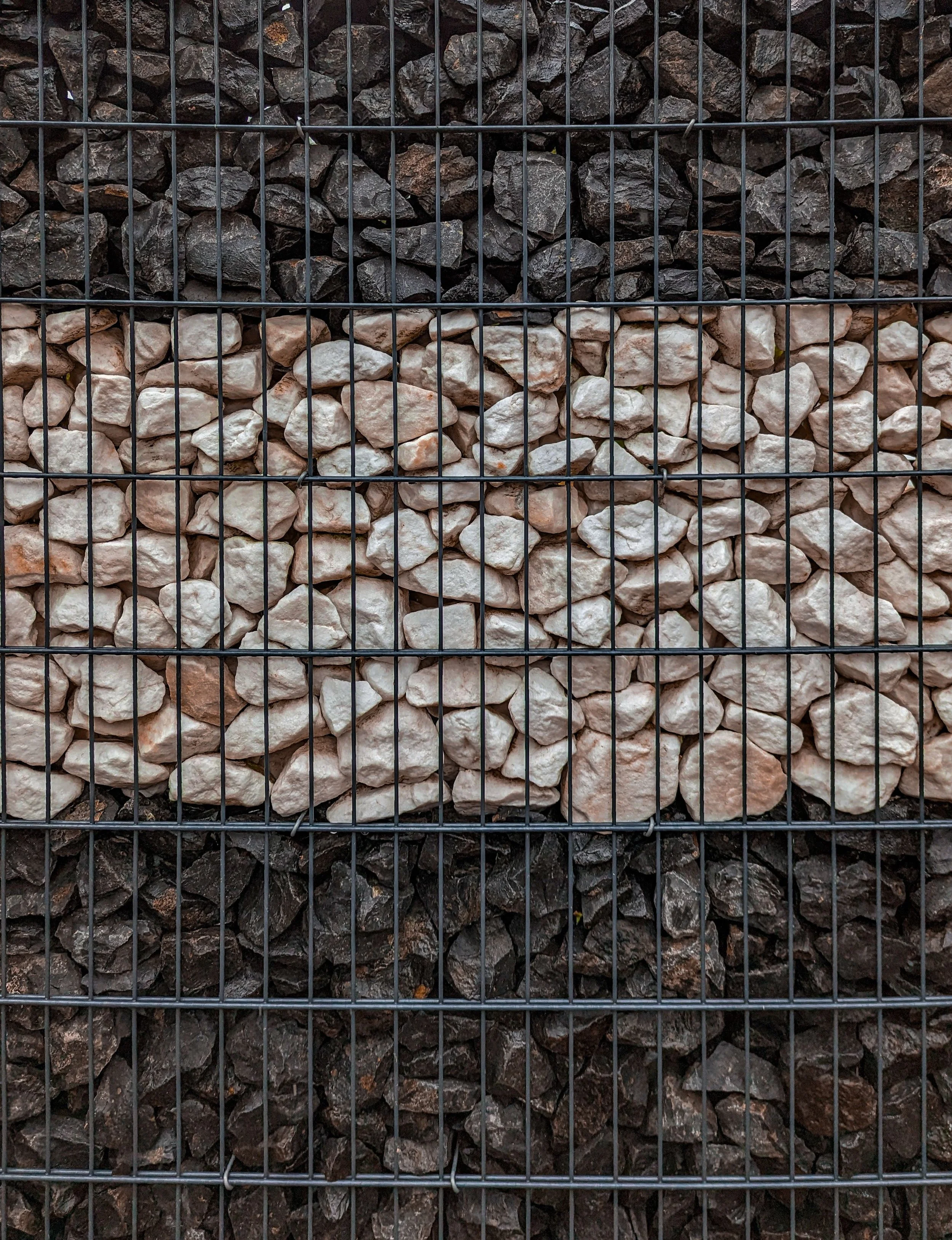 Lärmschützende Gabionenwand befüllt mit hellen Natursteinen für Sichtschutz in Frankfurt