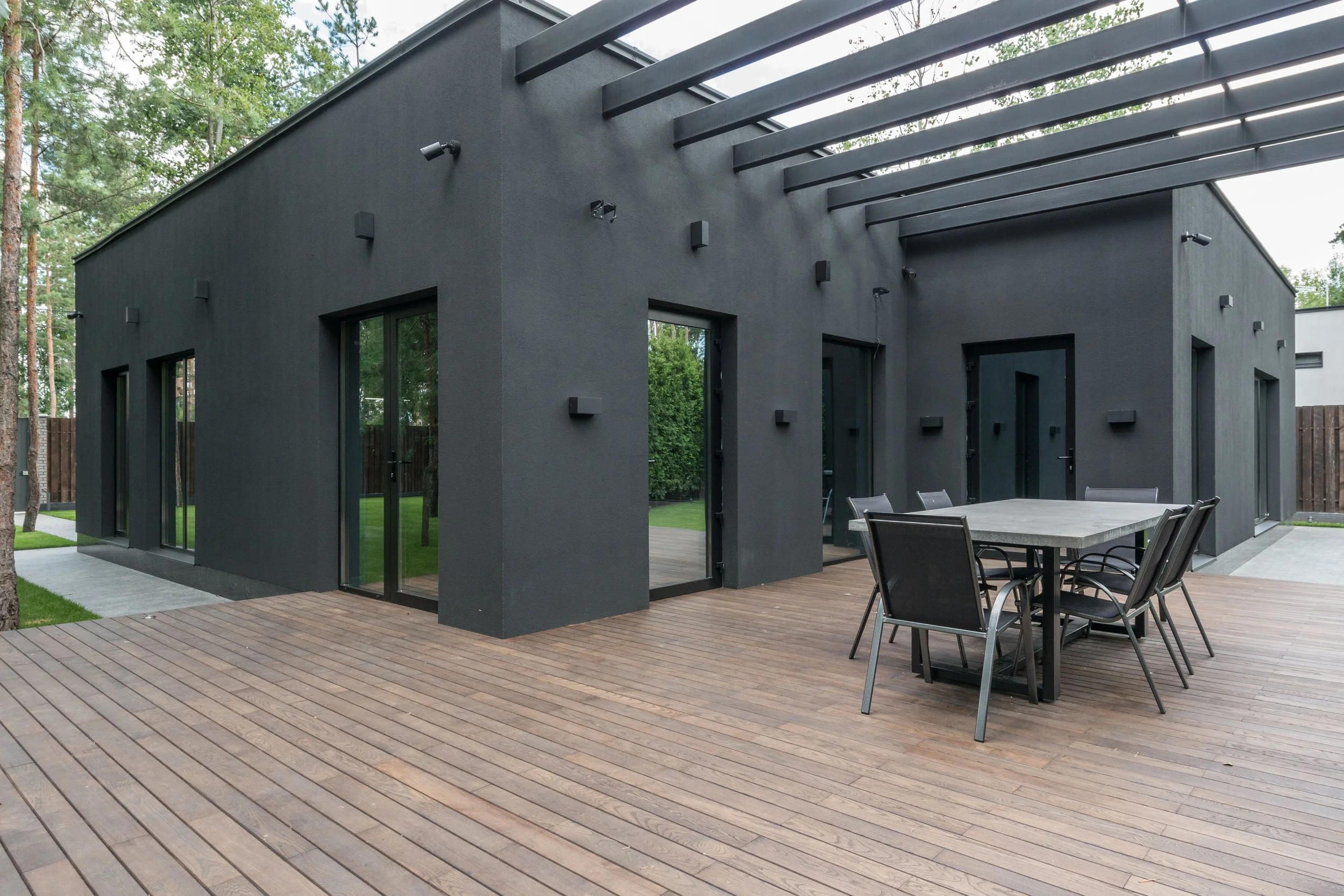 Moderne Terrassengestaltung mit großformatigen Belägen und Sitzgruppe an einem modernen Wohnhaus im Taunus