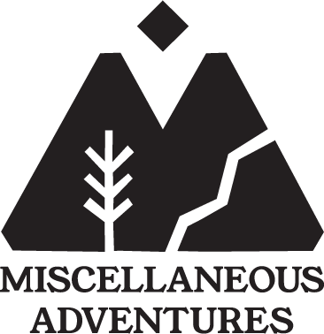 Logo with mountain peaks, a tree, and a zigzag path above the text 'Miscellaneous Adventures'