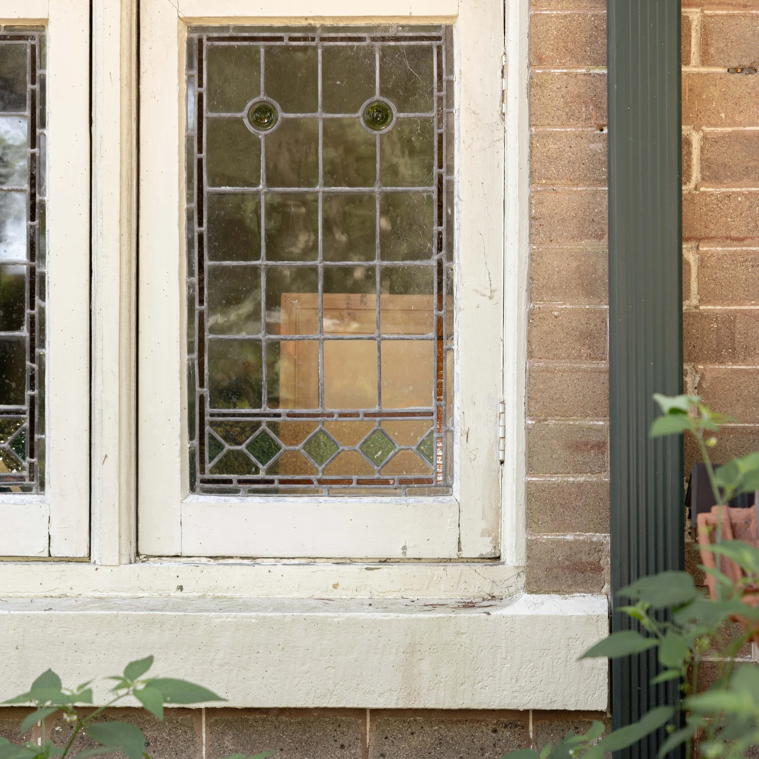 Before restoration photograph of original leadlight glazing in a Federation heritage home in Killara, Sydney, featuring decorative coloured glass panels, traditional leadwork and weathered timber window frames.