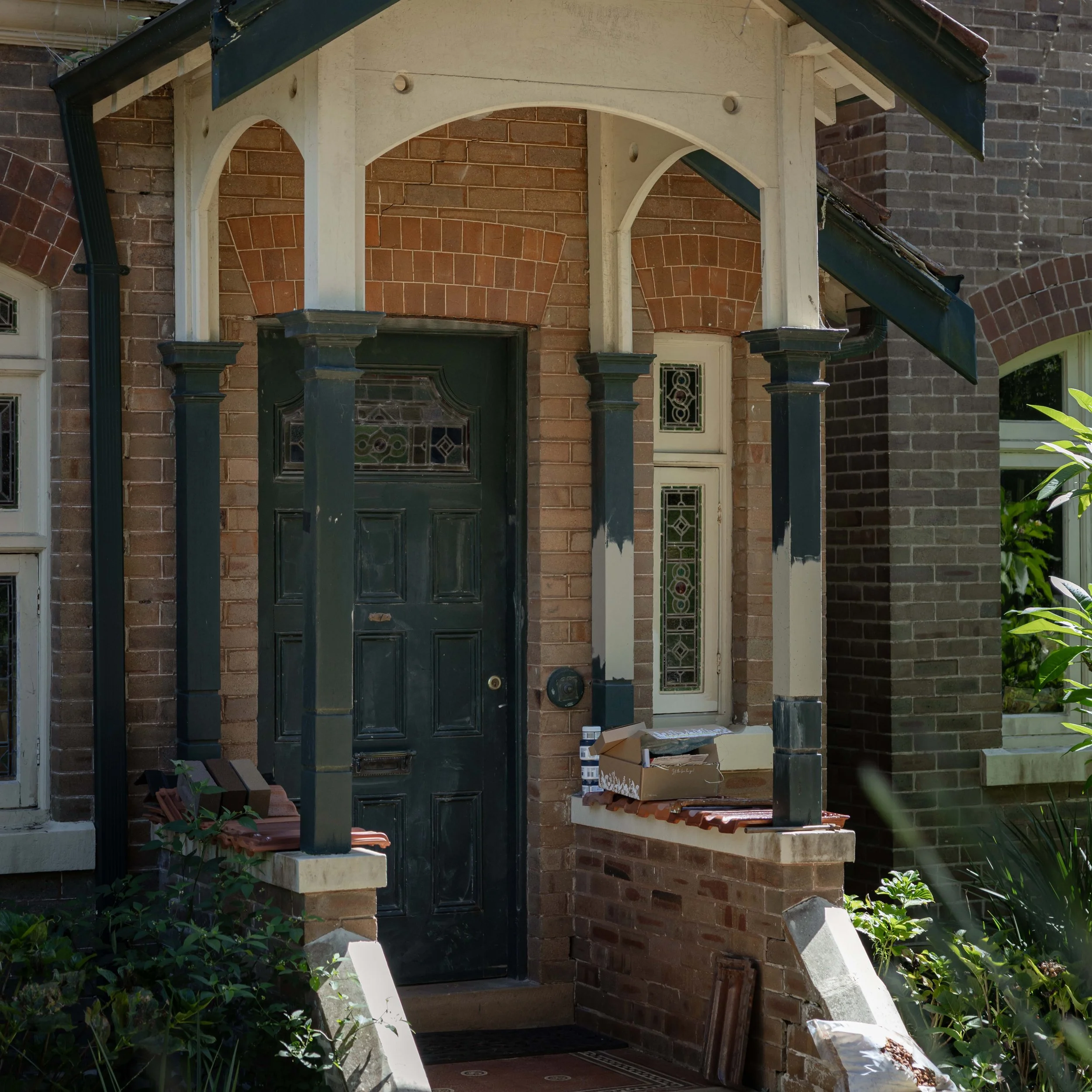 before photo of Heritage home entrance with decorative timber posts, arched verandah trimwork and original leadlight windows.