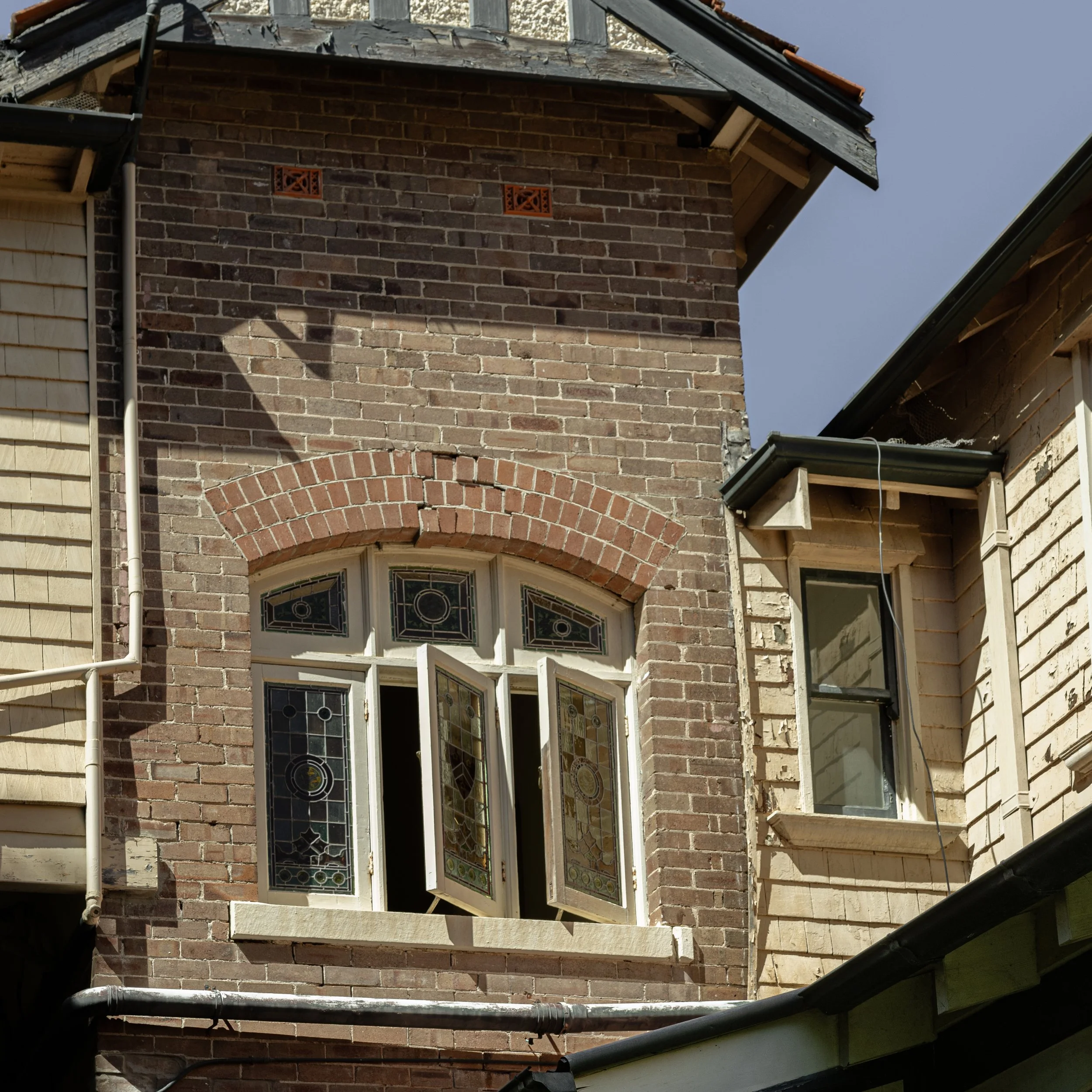 Before restoration photograph of a Queen Anne Federation heritage home's brick façade in Sydney, featuring traditional brickwork, an arched brick lintel and original leadlight windows, prior to brick repairs and repointing.