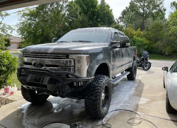 Lifted black truck covered in foam during deep wash & detailing by Christal Clean in Palm Coast, FL