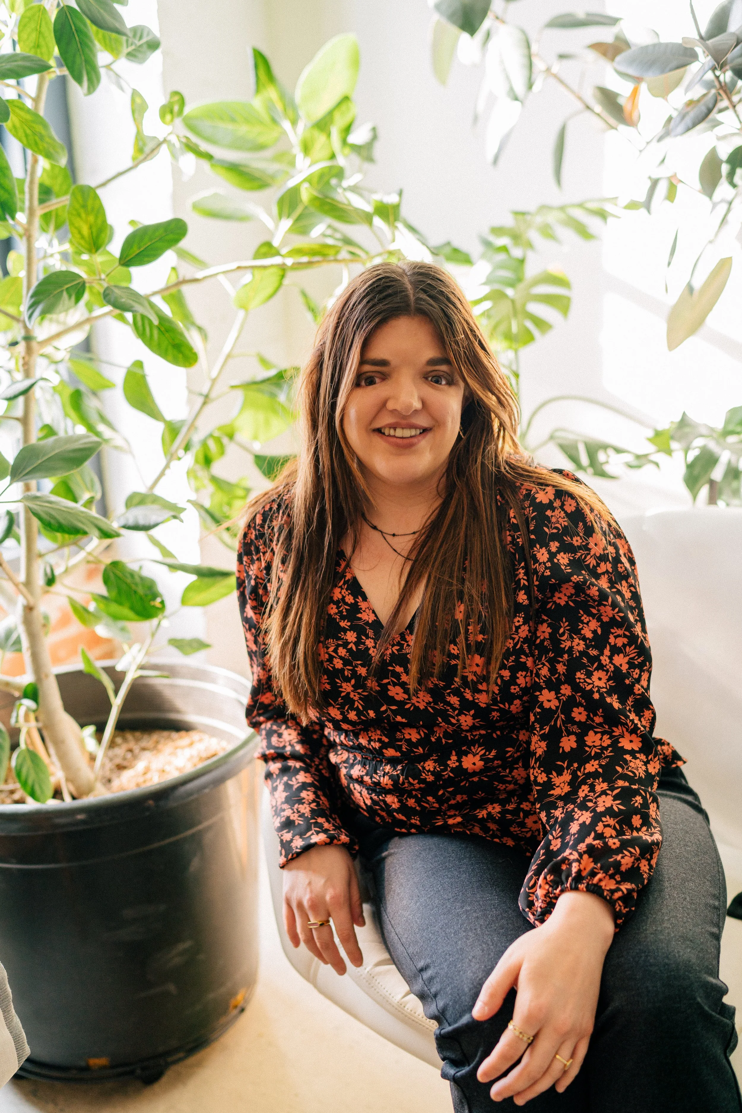 Accessibility Consultant, Ariel Henley, sitting in a white chair and smiling for a photo.