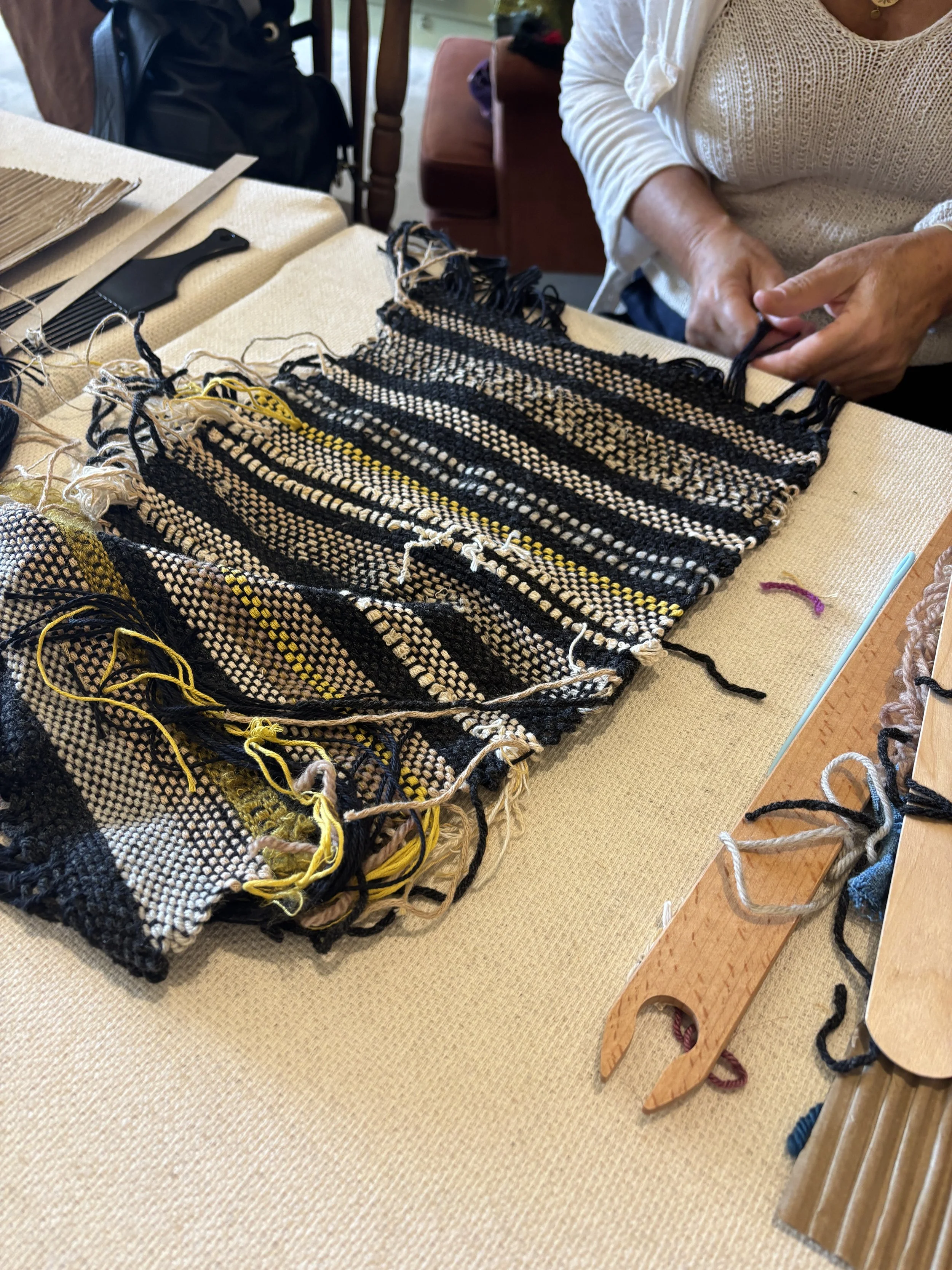 woman knotting the fringe of her weaving