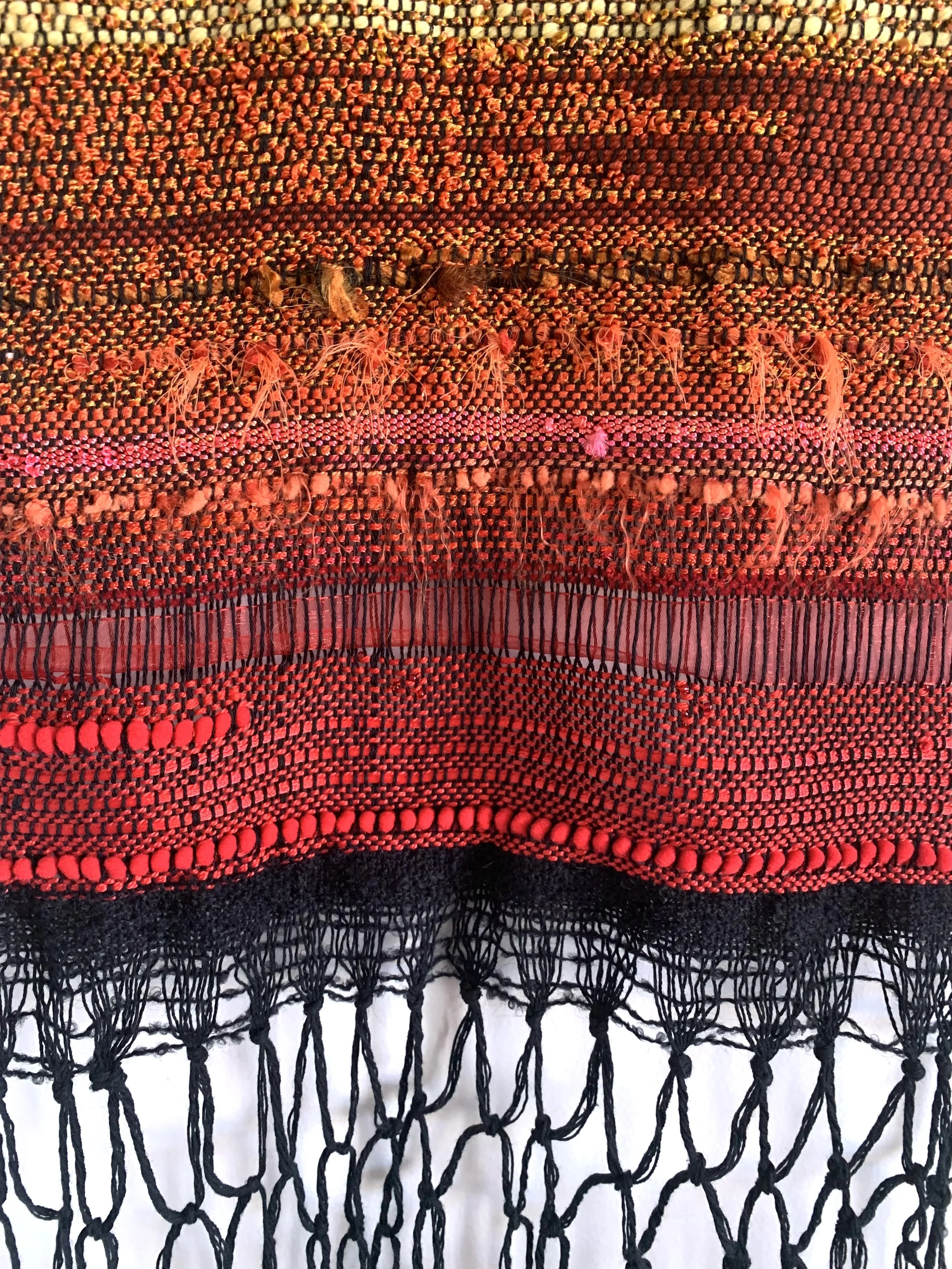 close up of orange and red weaving