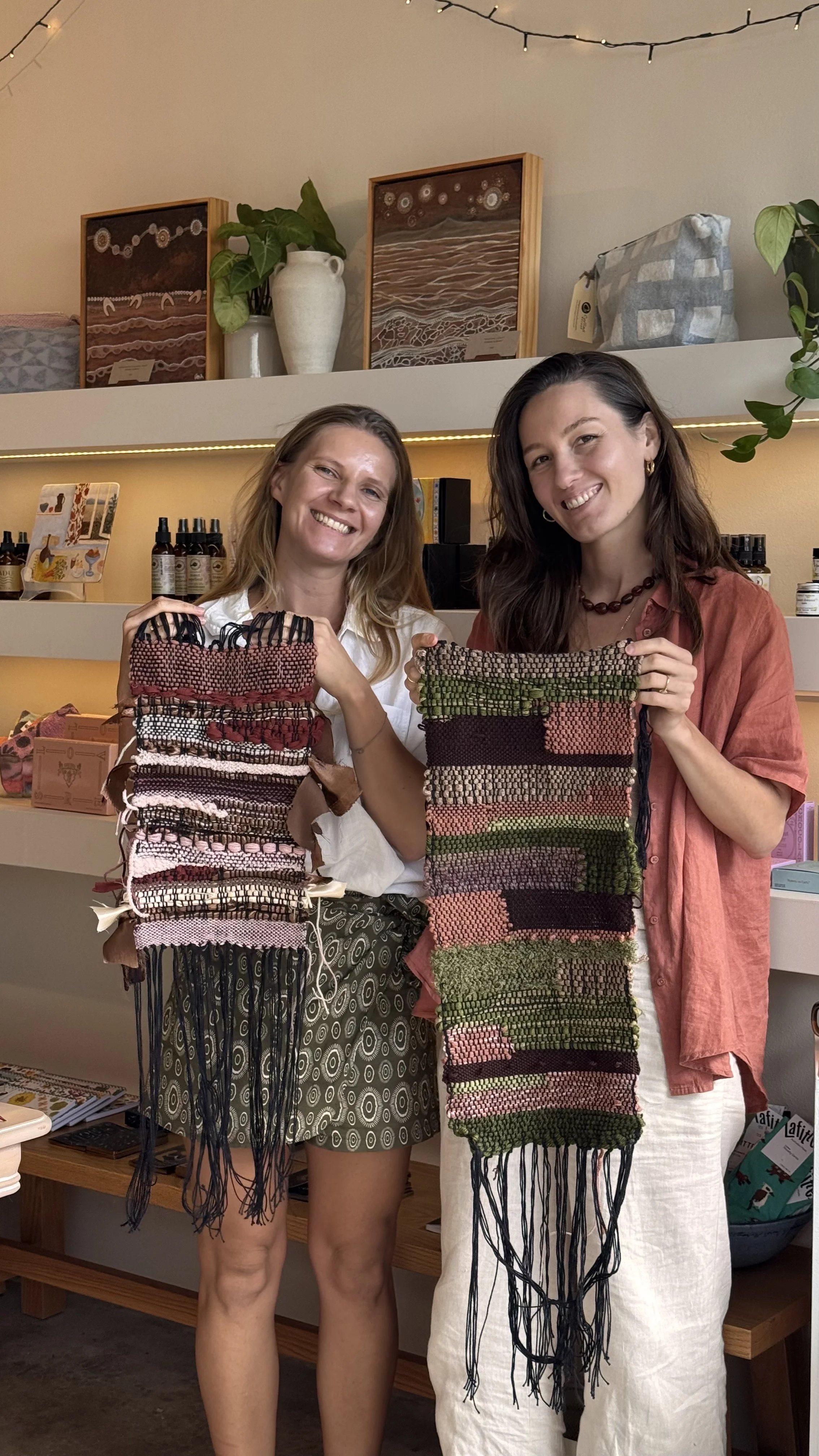 2 women smiling and holding weaving