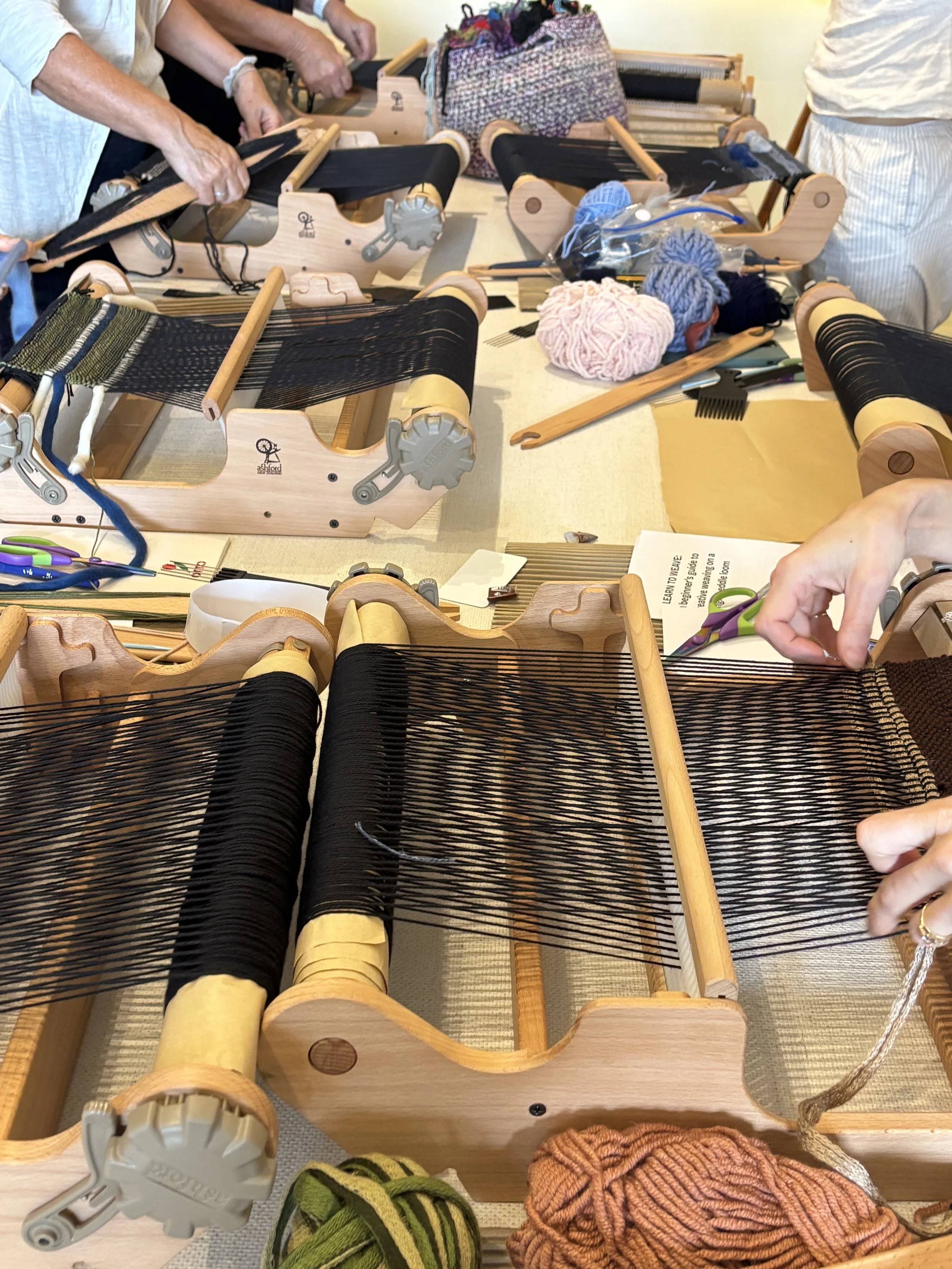 table full of weaving looms