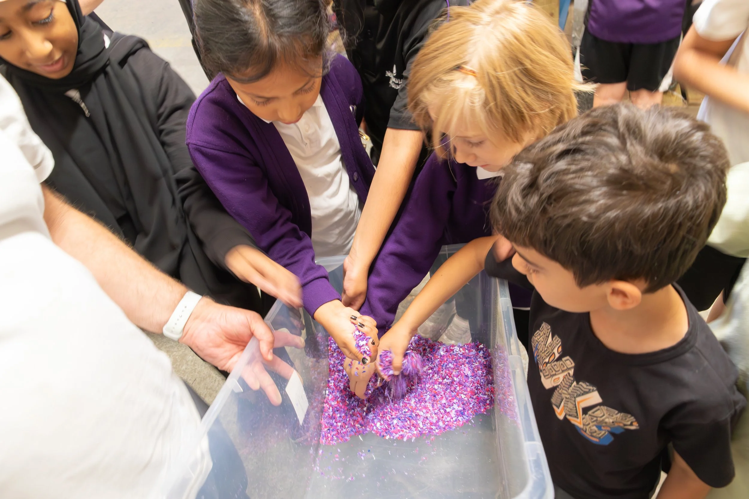 Eco Leaders holding the granulated purple bottle tops