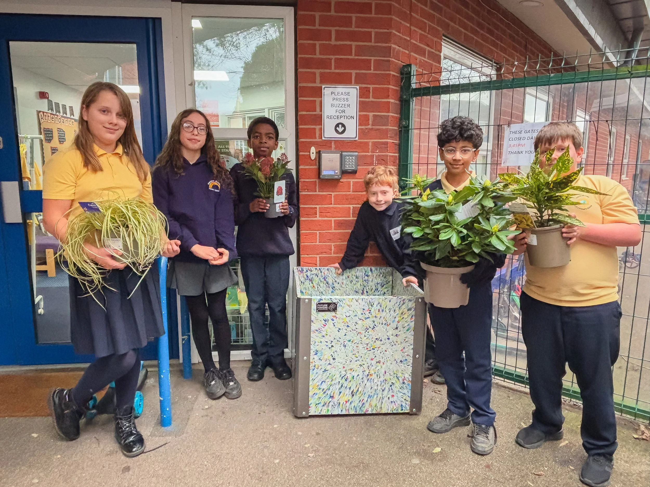 Pupils at South Wilford Primary with recycled plastic planter made from their collection