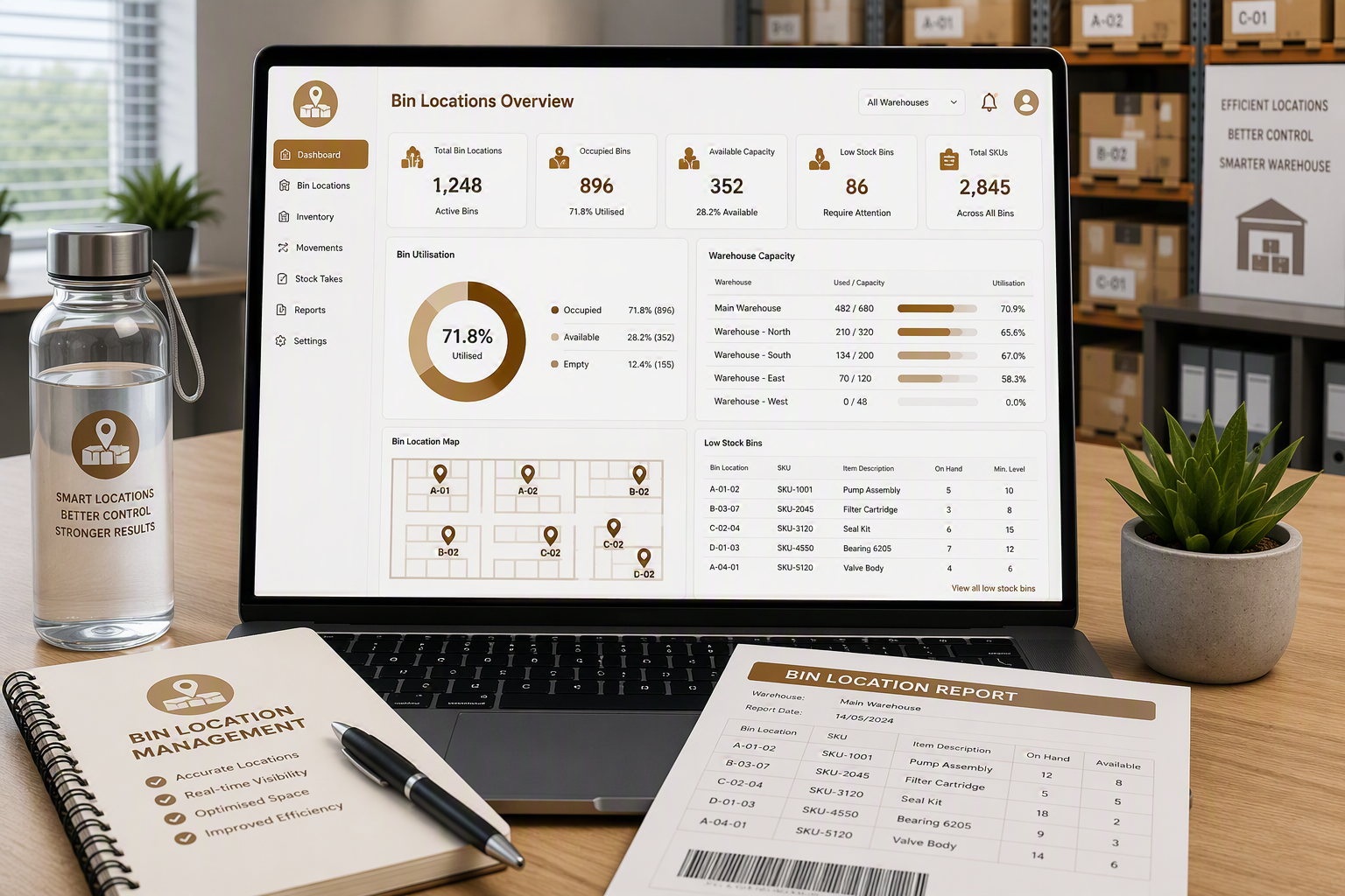 A desk with a laptop displaying warehouse bin locations and inventory data, a water bottle with a logo and motivational message, a notebook with a pen, a printed report titled 'Bin Location Report,' and a small potted plant.