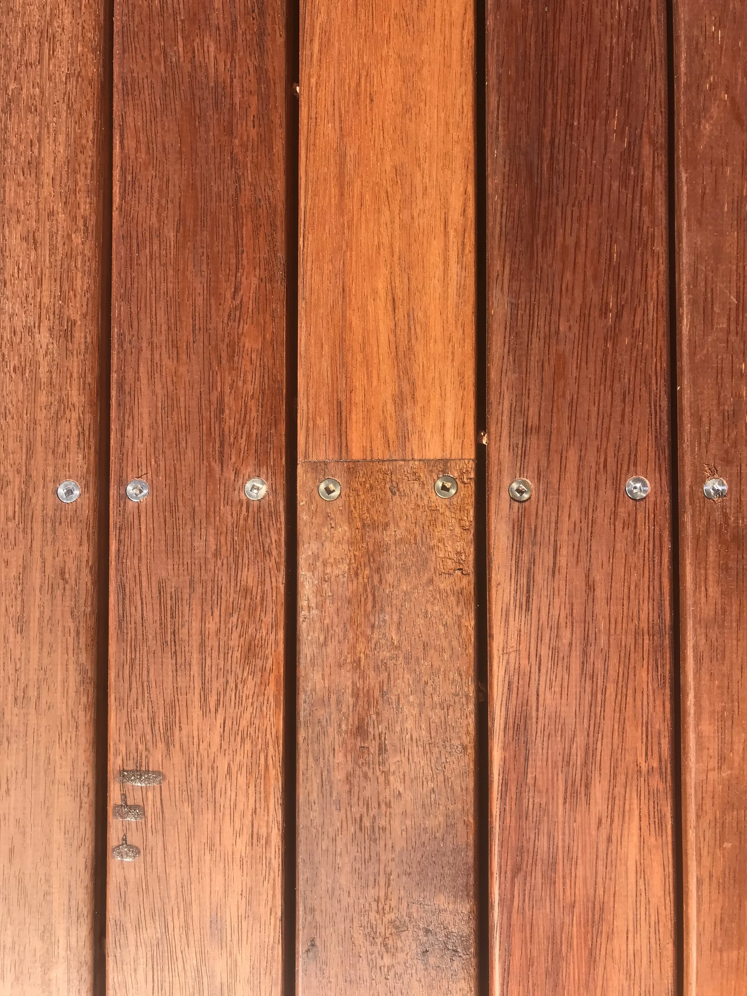 Close-up view of polished wooden wall panels with visible screws.
