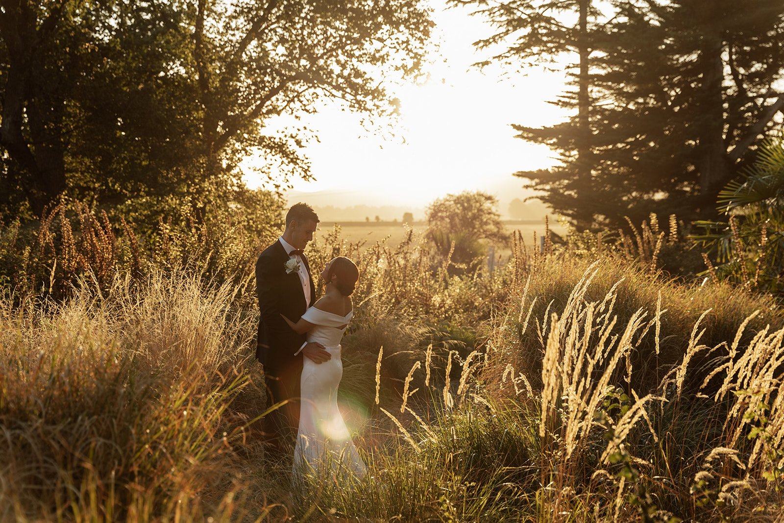 A bride and groom hug in the middle of a field at sunset at Yering Station in Yarra Valley, Melbourne.