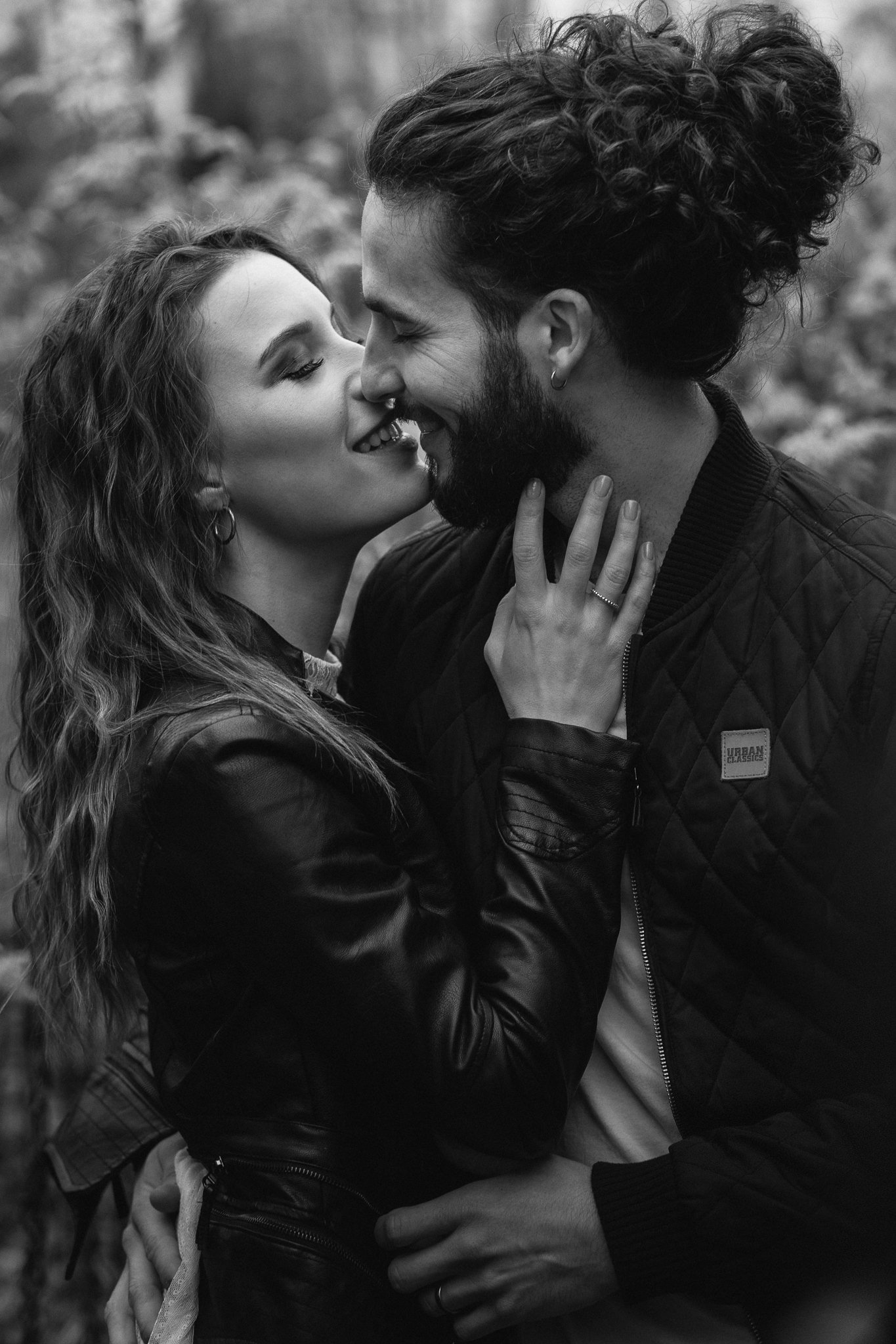 Ein verliebtes Paar umarmt sich und küsst sich im Freien, im Schwarz-Weiß-Foto.