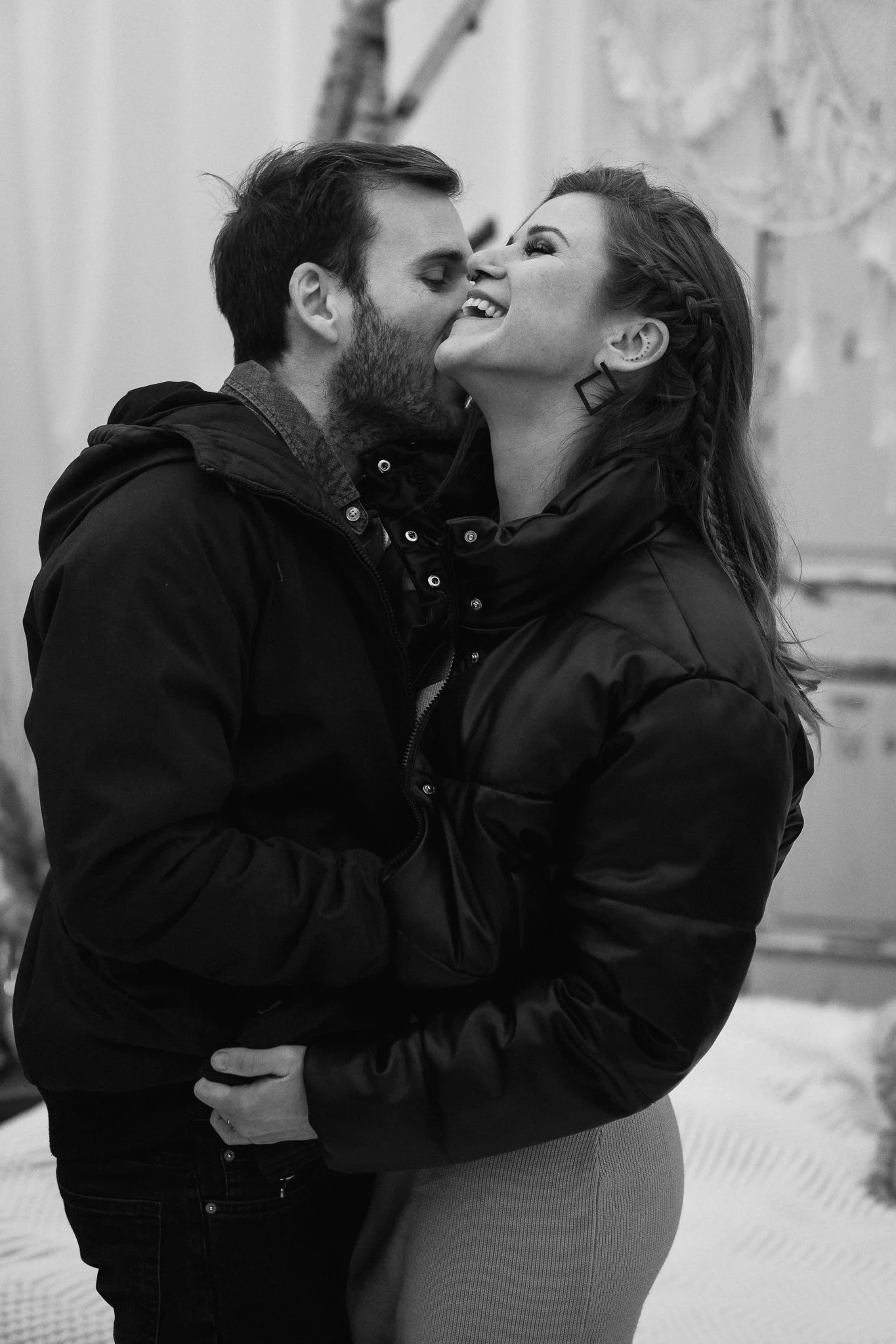 Ein Mann und eine Frau umarmen sich und küssen sich im Schwarz-Weiß-Foto.