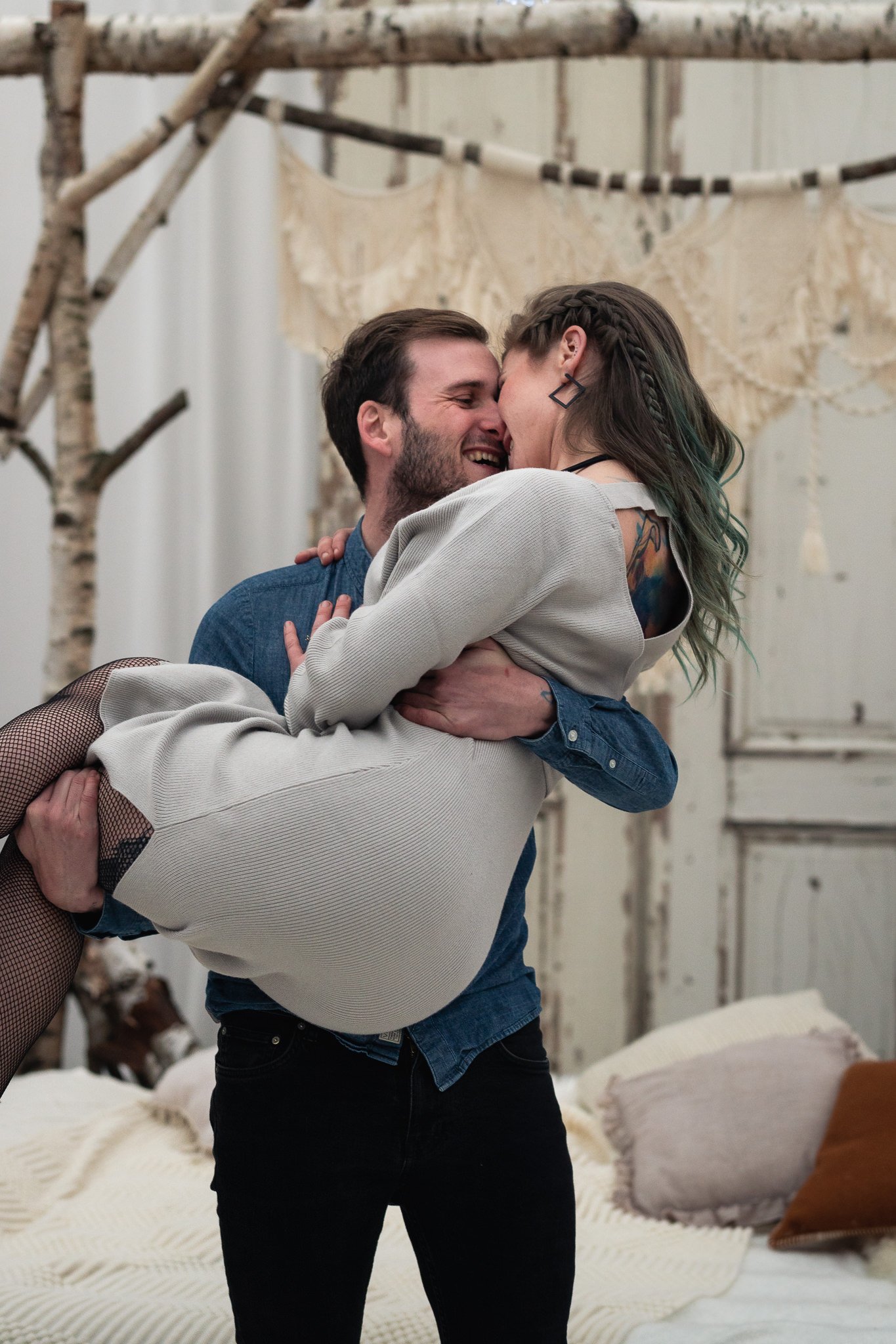 Ein Mann hält eine lächelnde Frau in den Armen, beide sind sehr glücklich verkehrt zueinander.