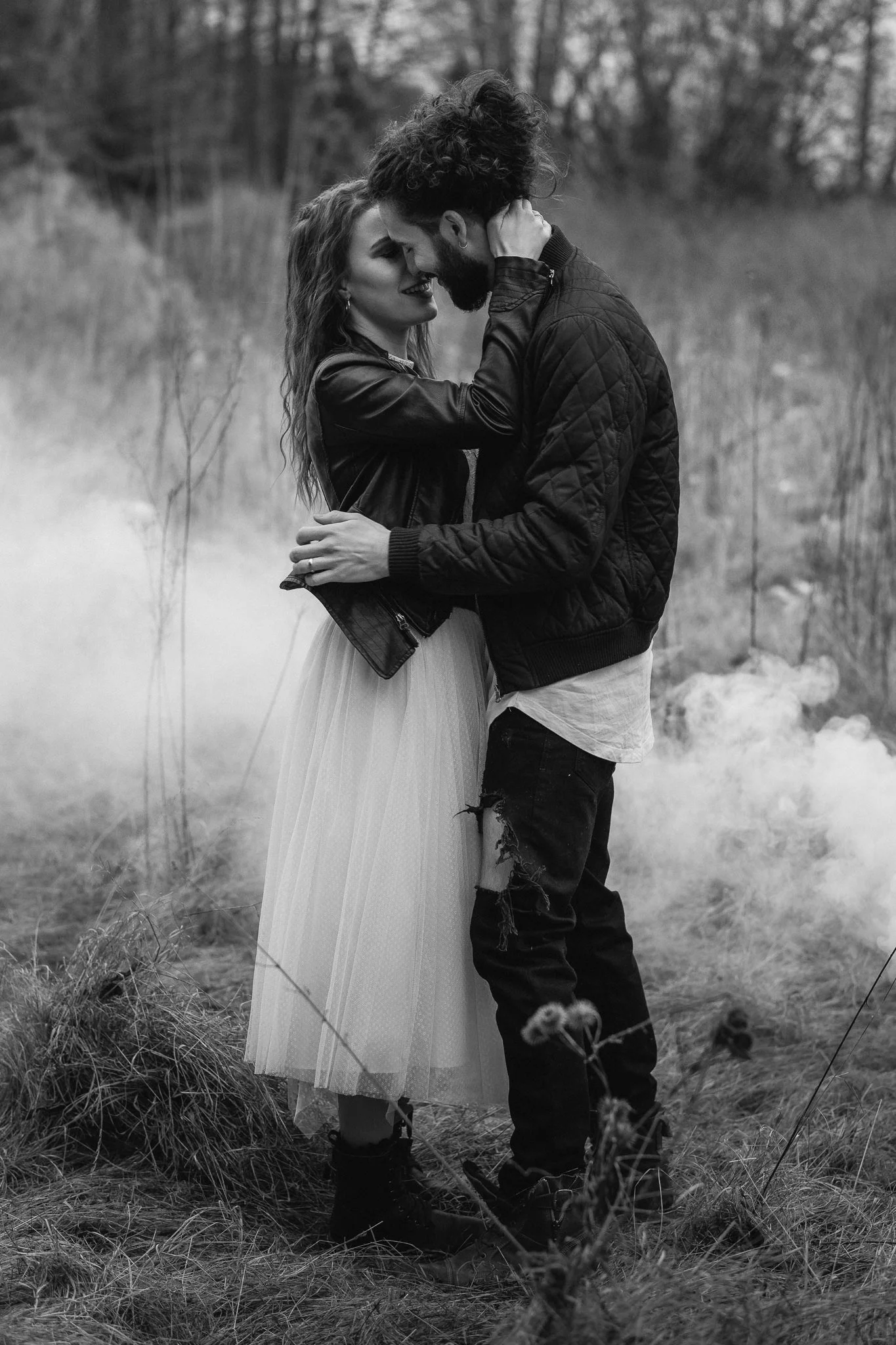 Ein Paar umarmt sich liebevoll in einem magischen, nebligen Naturlandschaft, schwarz-weiß Fotografie.