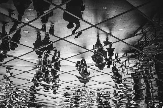 People walking on a mirrored floor creating a reflection effect.