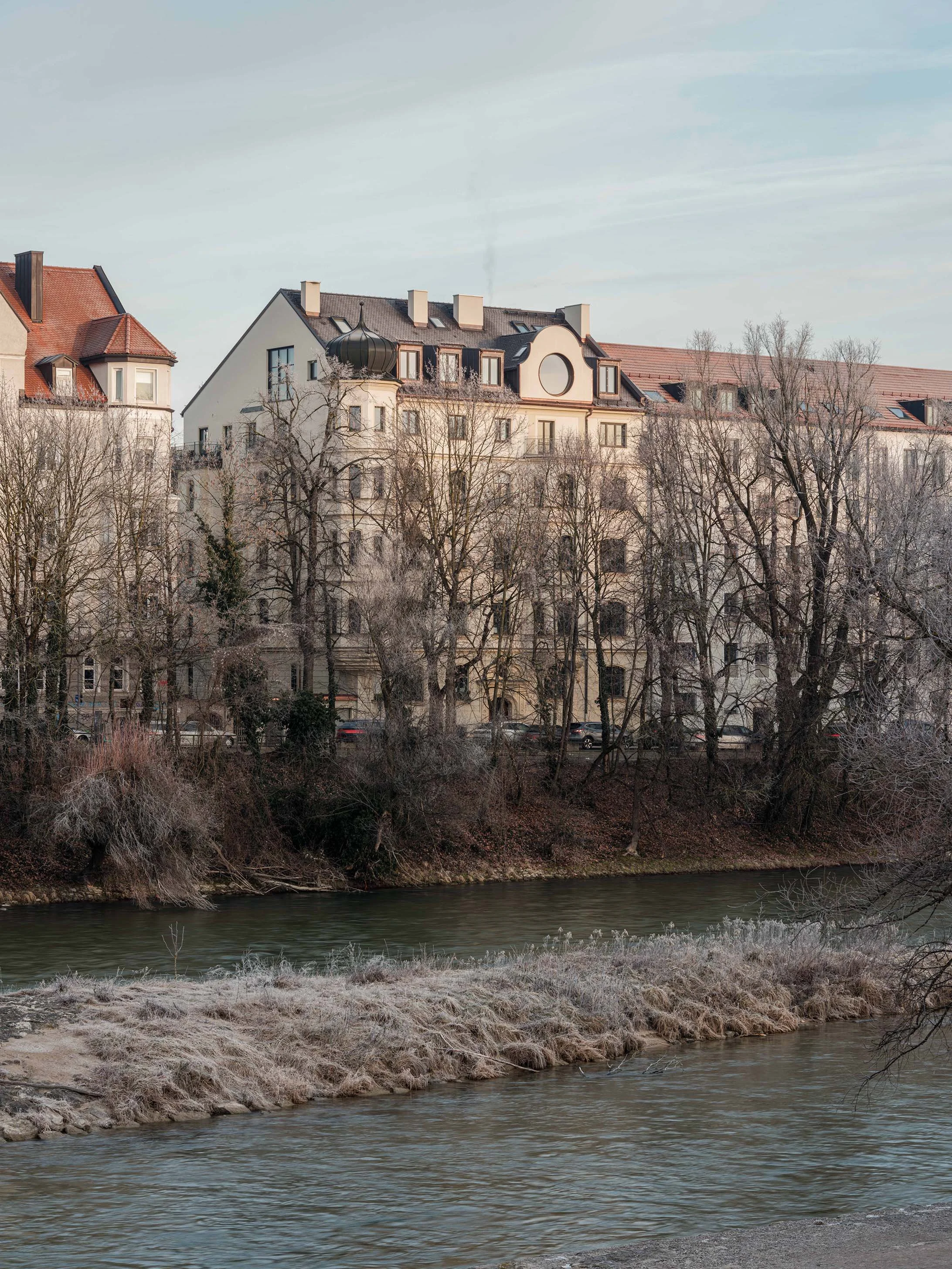 Das denkmalgeschützte Haus in München wurde umfassend ausgebaut und mit einem großen runden Fenster mit Blick auf die Isar ergänzt.