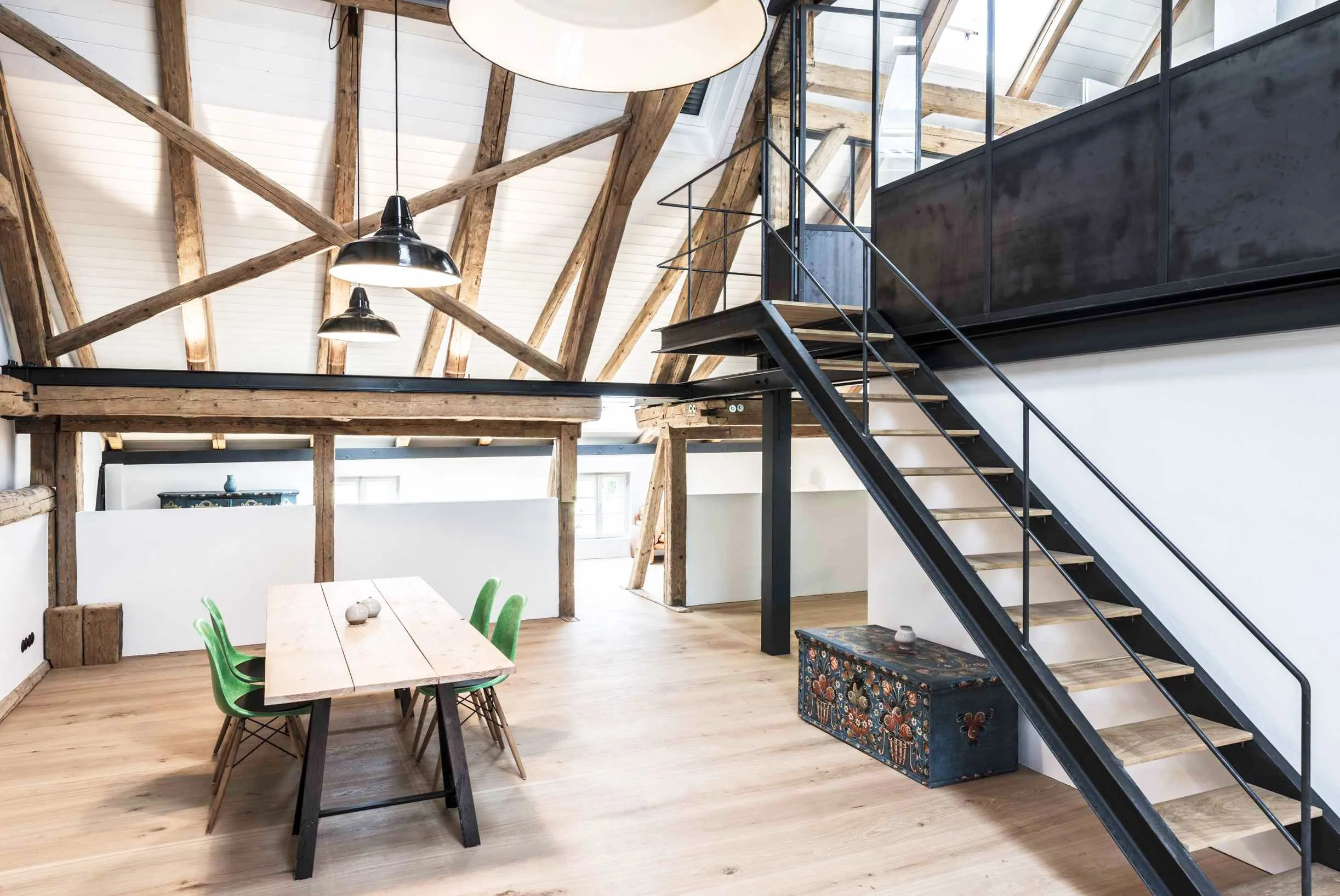 Das Bauernhaus wurde im Inneren neu gedacht und eine Stahltreppe verbindet die Galerie mit dem Esszimmer