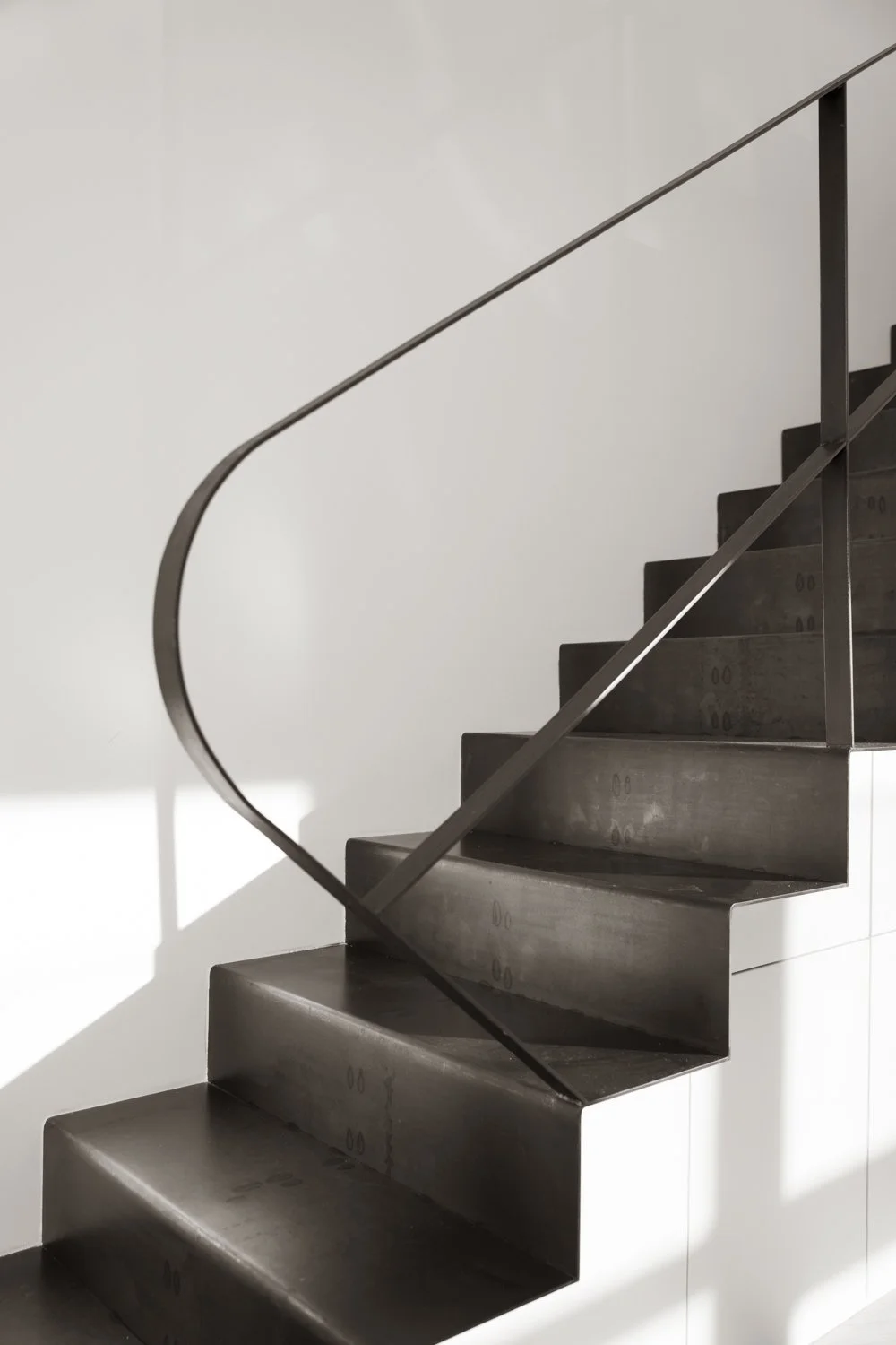 Die schlichte gefaltete Stahltreppe verbindet das untere Geschoss der Maisonette Wohnung mit den oberen Schlafzimmern.