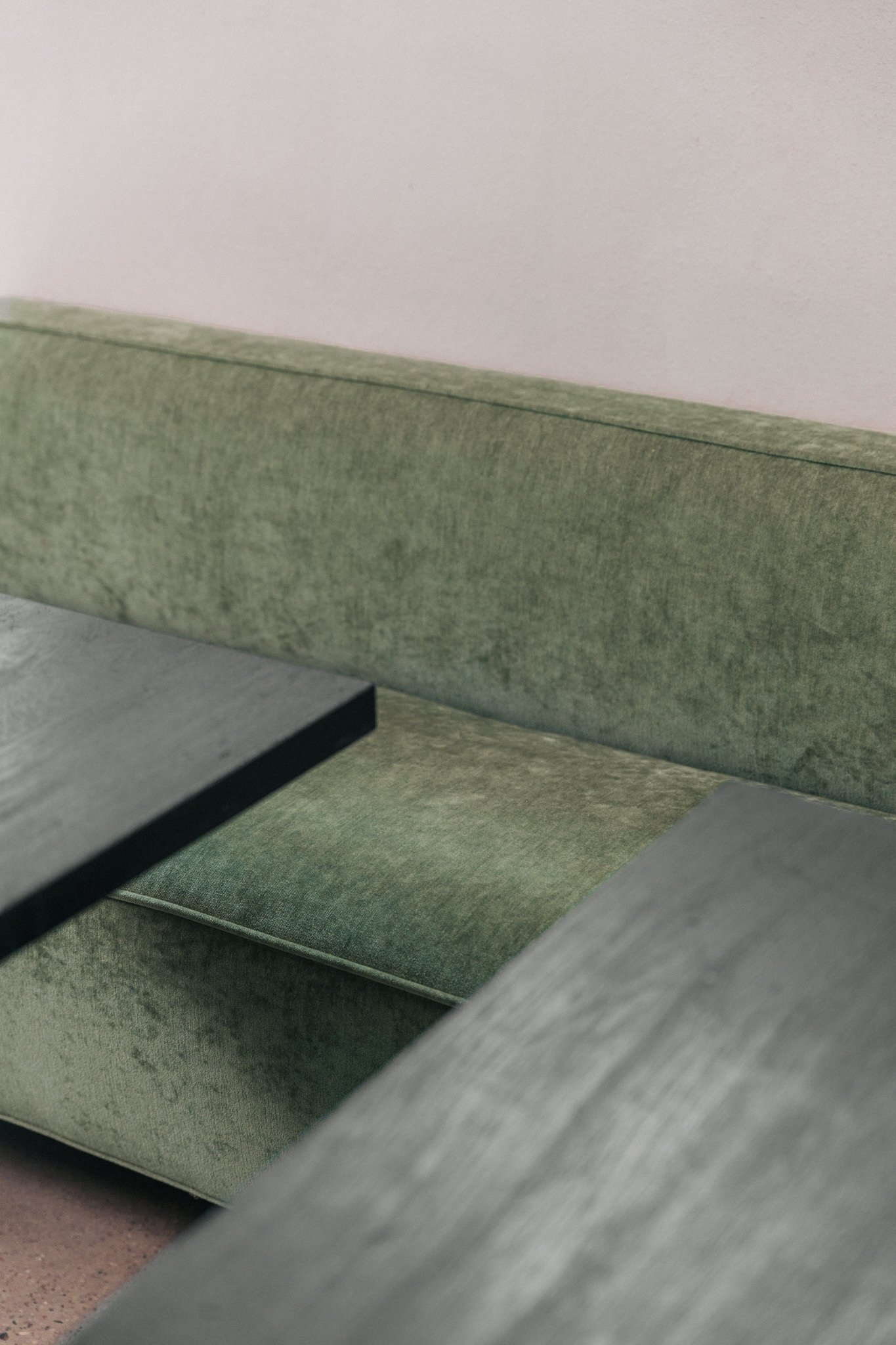 Die salbeigrünen Sofas im Restaurant bilden einen schönen Kontrast zum Schwarzstahl und schwarzen Holz der Tische