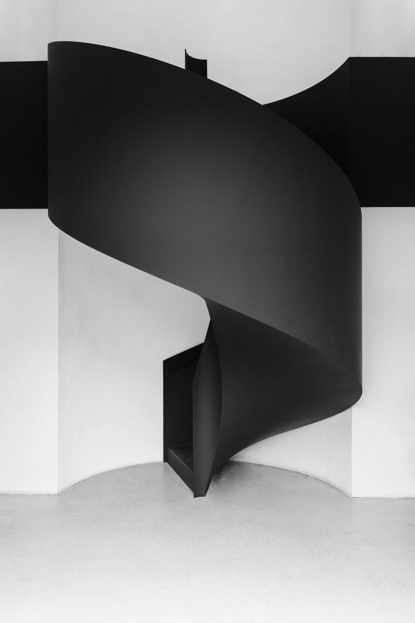 Die geschwungene Wendeltreppe aus Stahl verbindet skulptural das Untergeschoss mit dem Obergeschoss