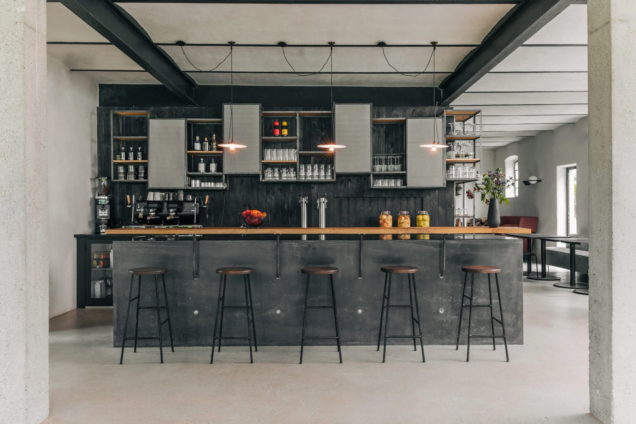 Die Bar im Restaurant ist aus Beton gegossen. Die Holzverkleidung hinter der Theke wurde mit der japanischen Yakisugi Technik abgeflammt.