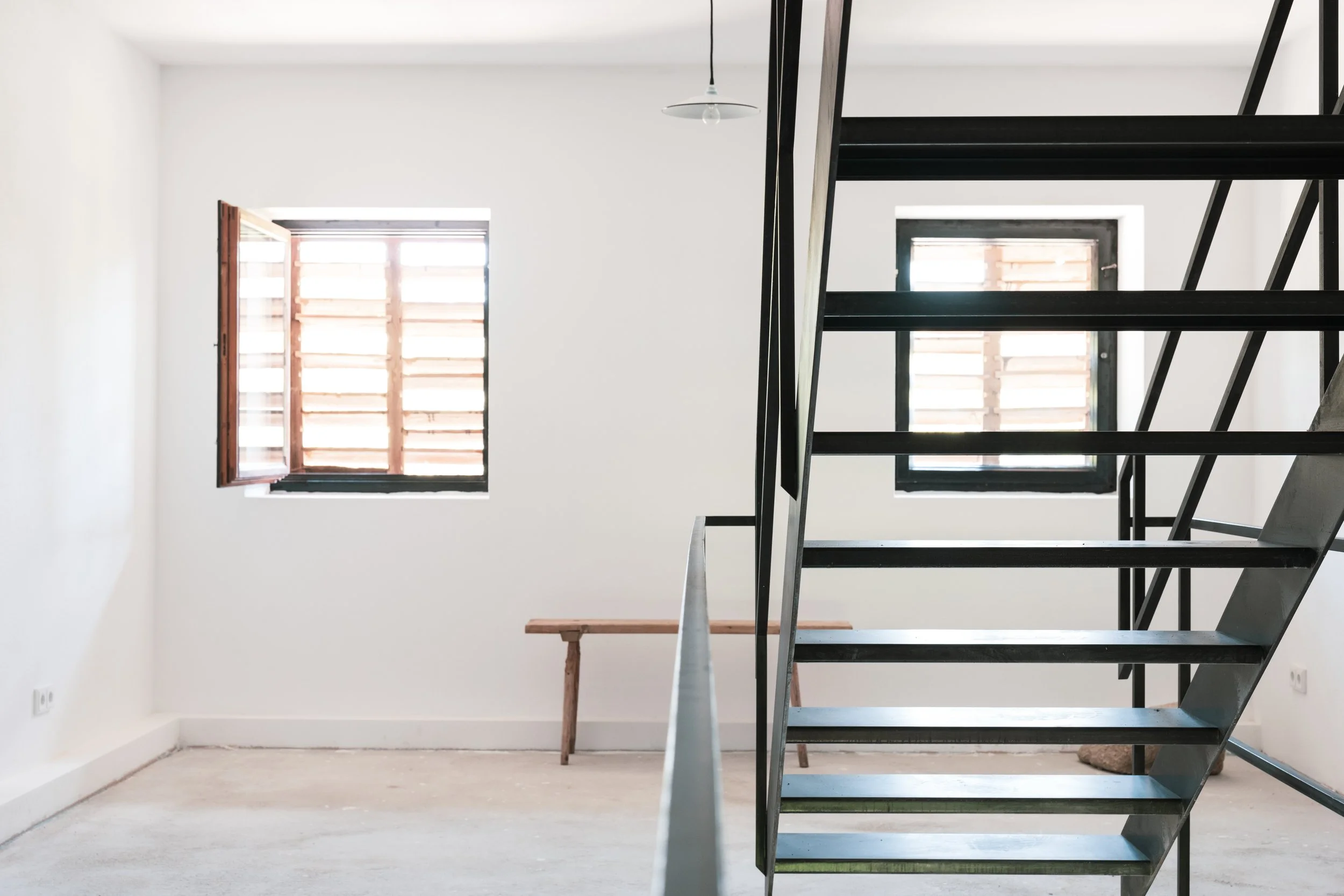 Die schlichte Treppe aus Schwarzstahl führt in die oberen Geschosse des Bauernhauses