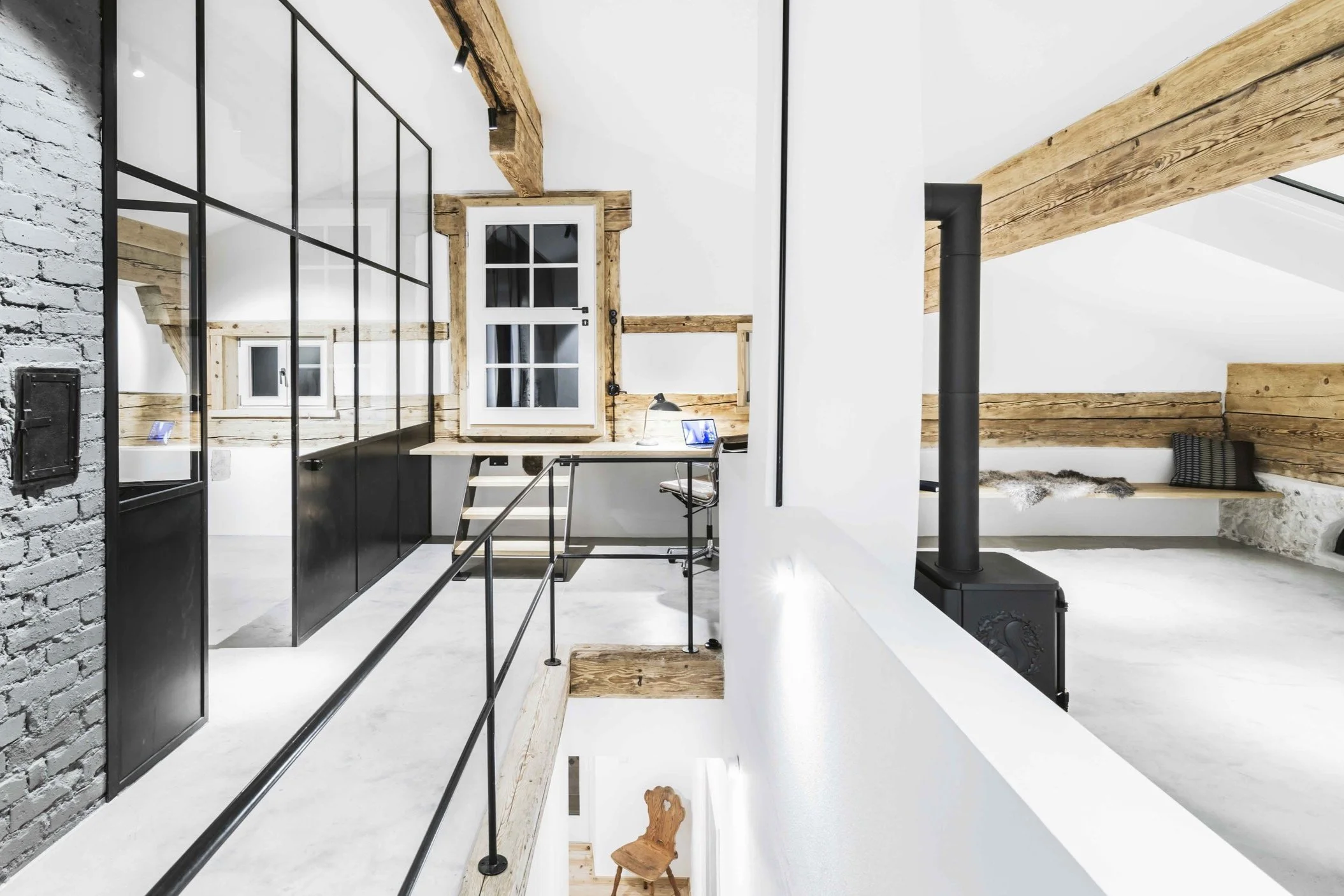 Im Dachgeschoss teilt eine loft-artige Stahl-Glas-Trennwand den Arbeitsbereich vom Schlafbereich