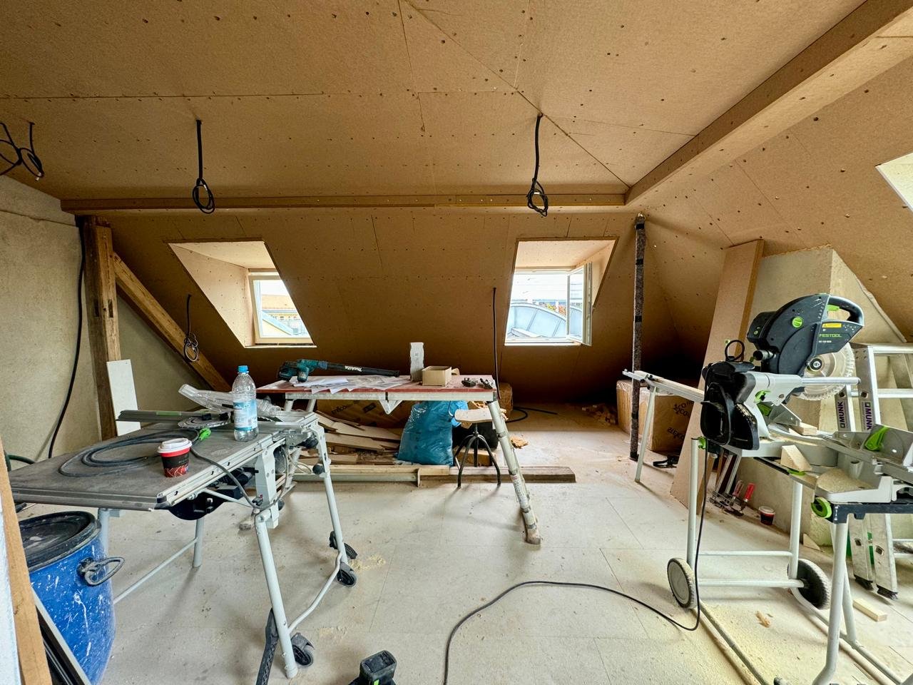 Innenansicht eines Dachgeschosses während der Bauphase einer Maisonette-Wohnung in München mit Wänden aus ökologischen Holzfaser-Ausbauplatten und Dachgauben.