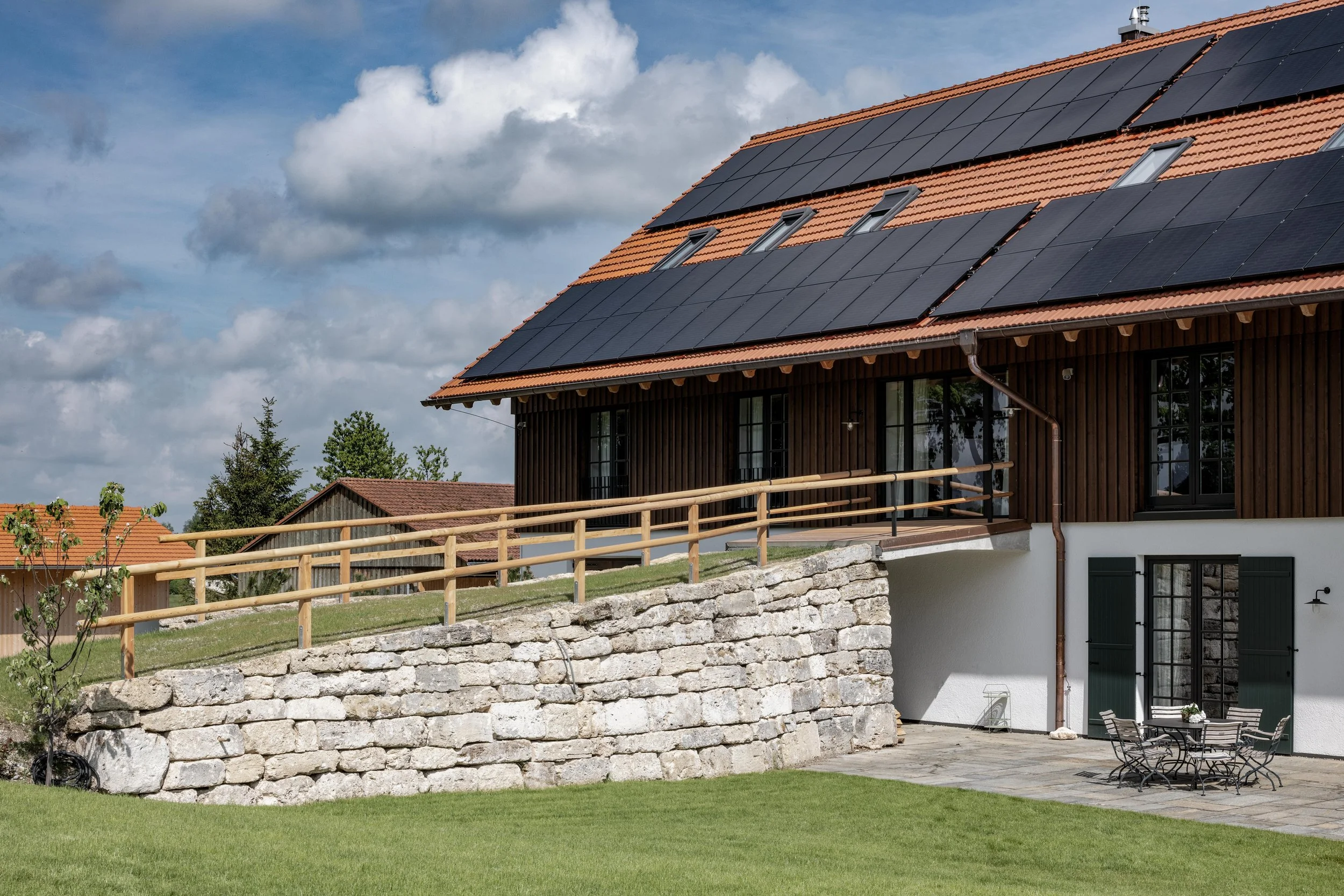 Tennenauffahrt an Südfassade eines sanierten Bauernhofes und Dach mit Solarpaneelen