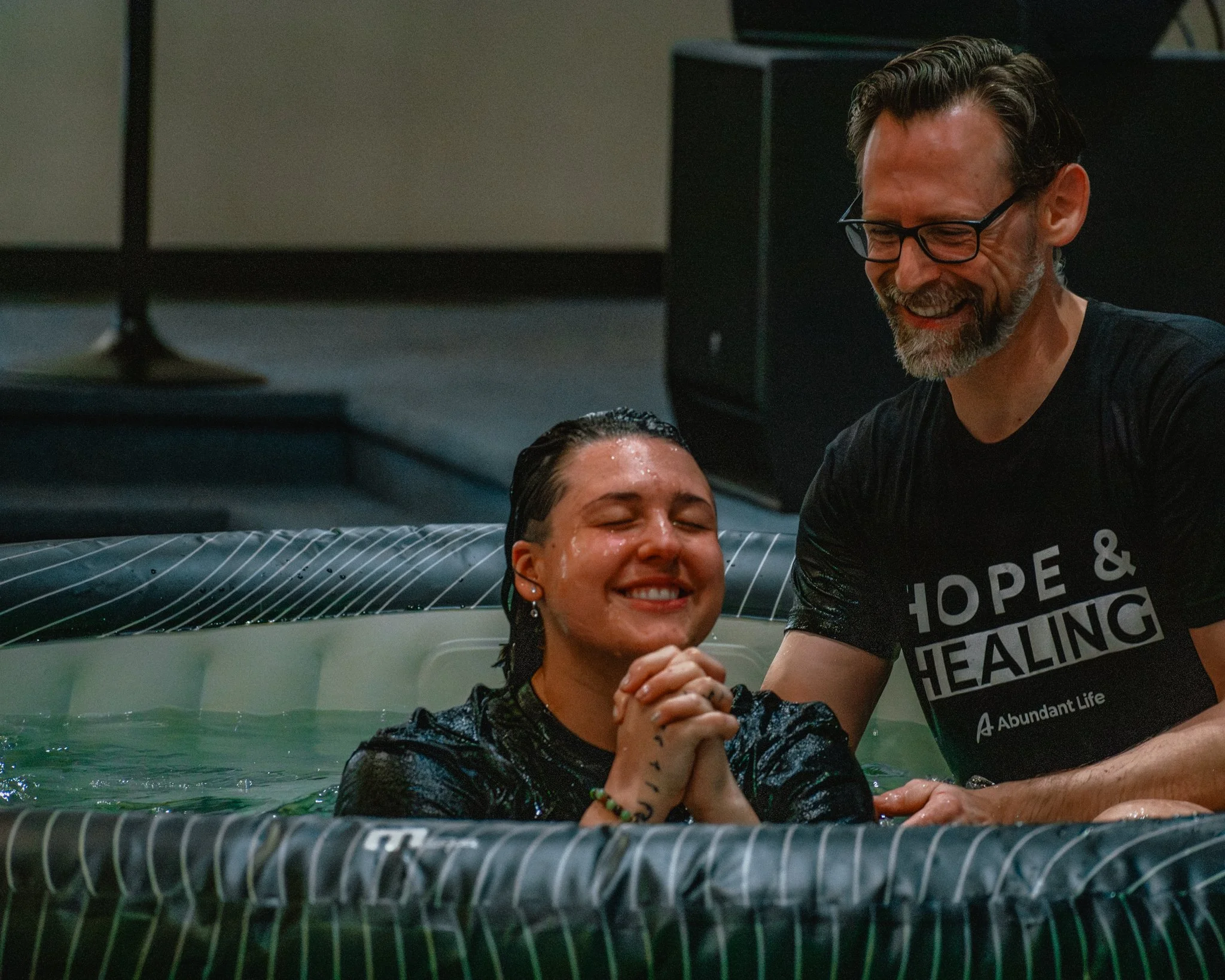 Young woman being baptized in water at Abundant Life Church in Wilmington, MA