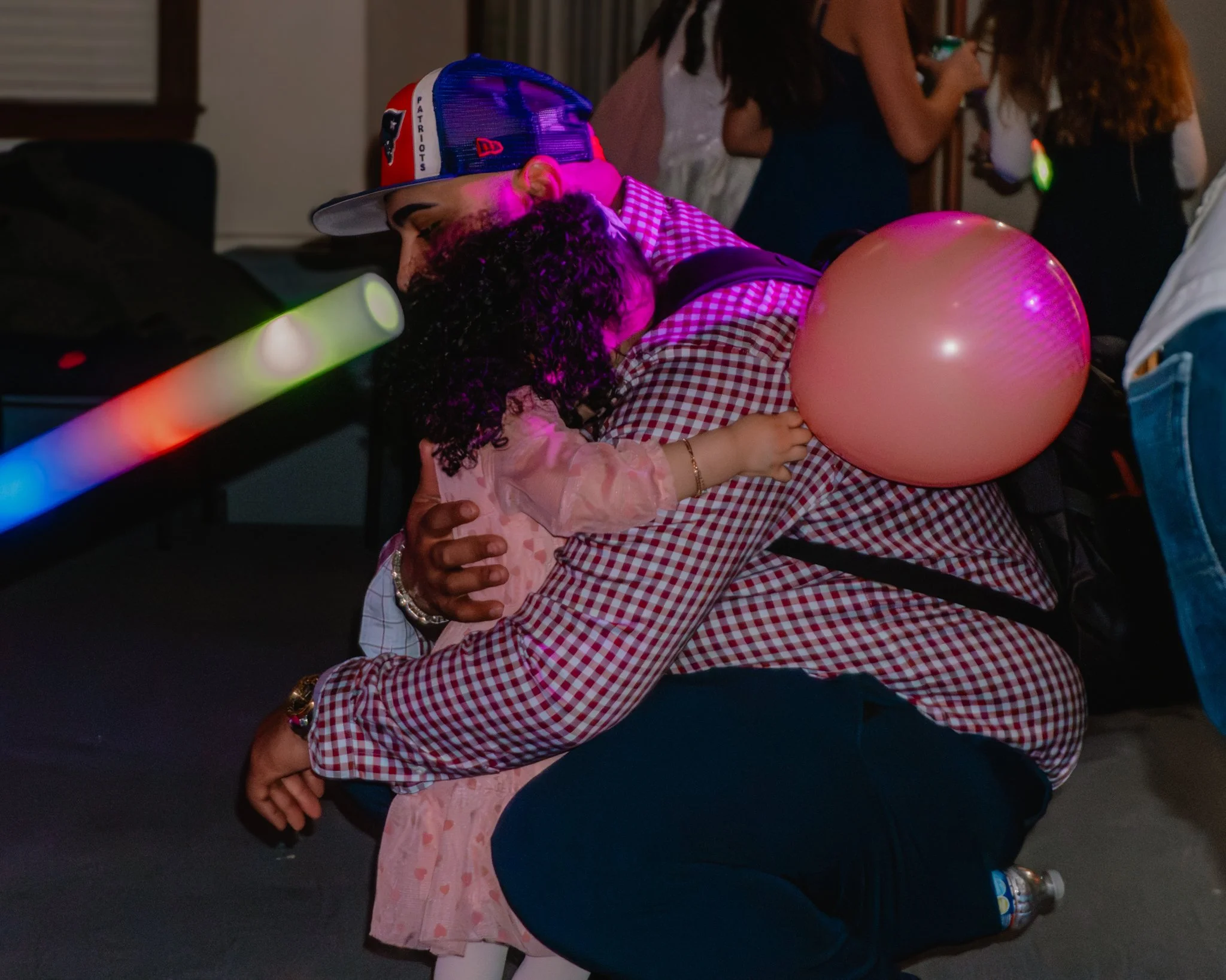 Father kneeling and hugging his daughter during the Daddy Daughter Dance at Abundant Life Church in Wilmington MA.