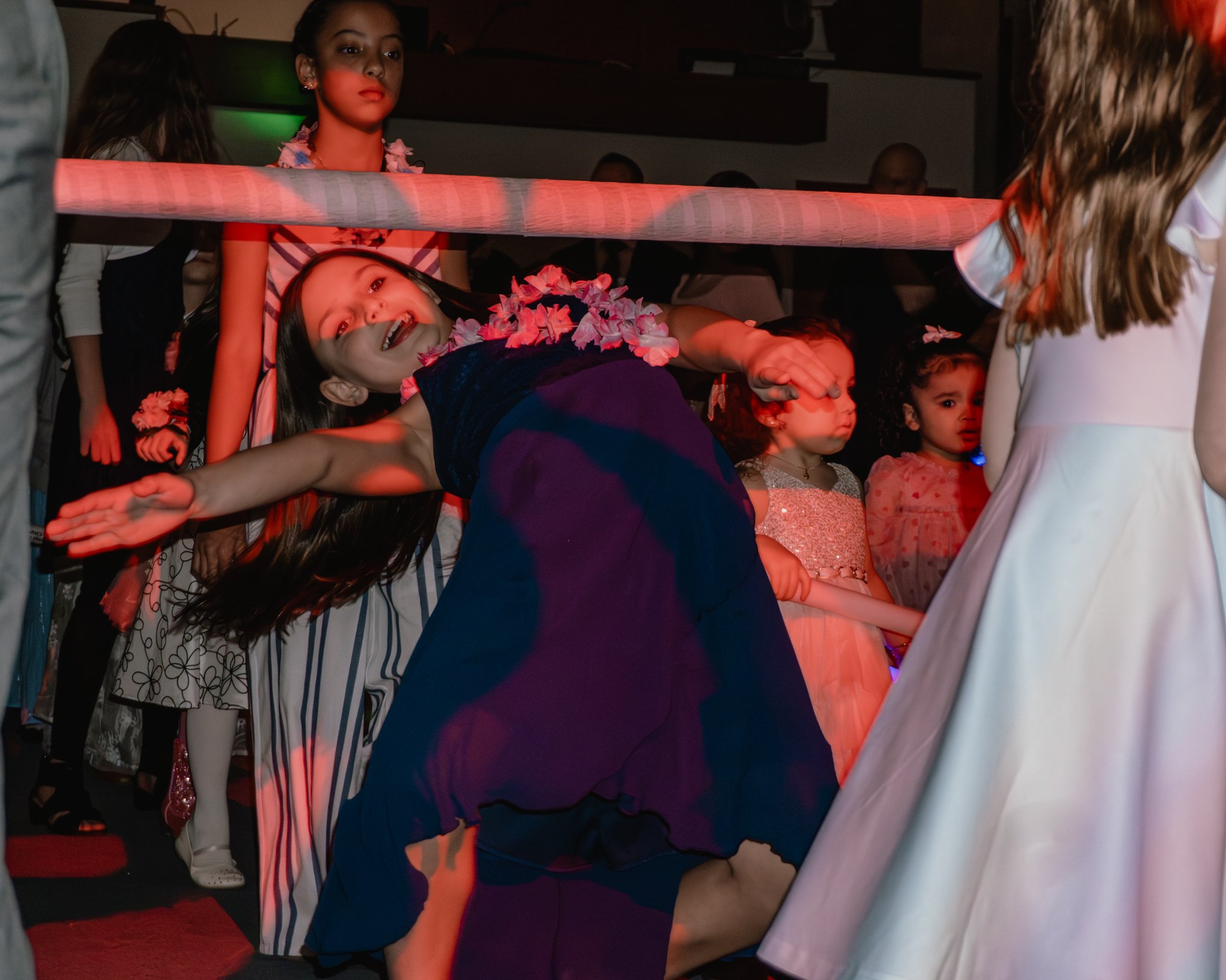 Girls playing limbo on the dance floor during the Daddy Daughter Dance at Abundant Life Church in Wilmington MA.