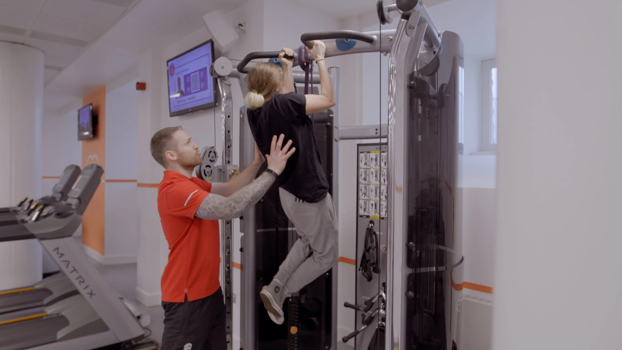 Personal trainer in Edinburgh assisting a client with pull ups as part of ongoing coaching support