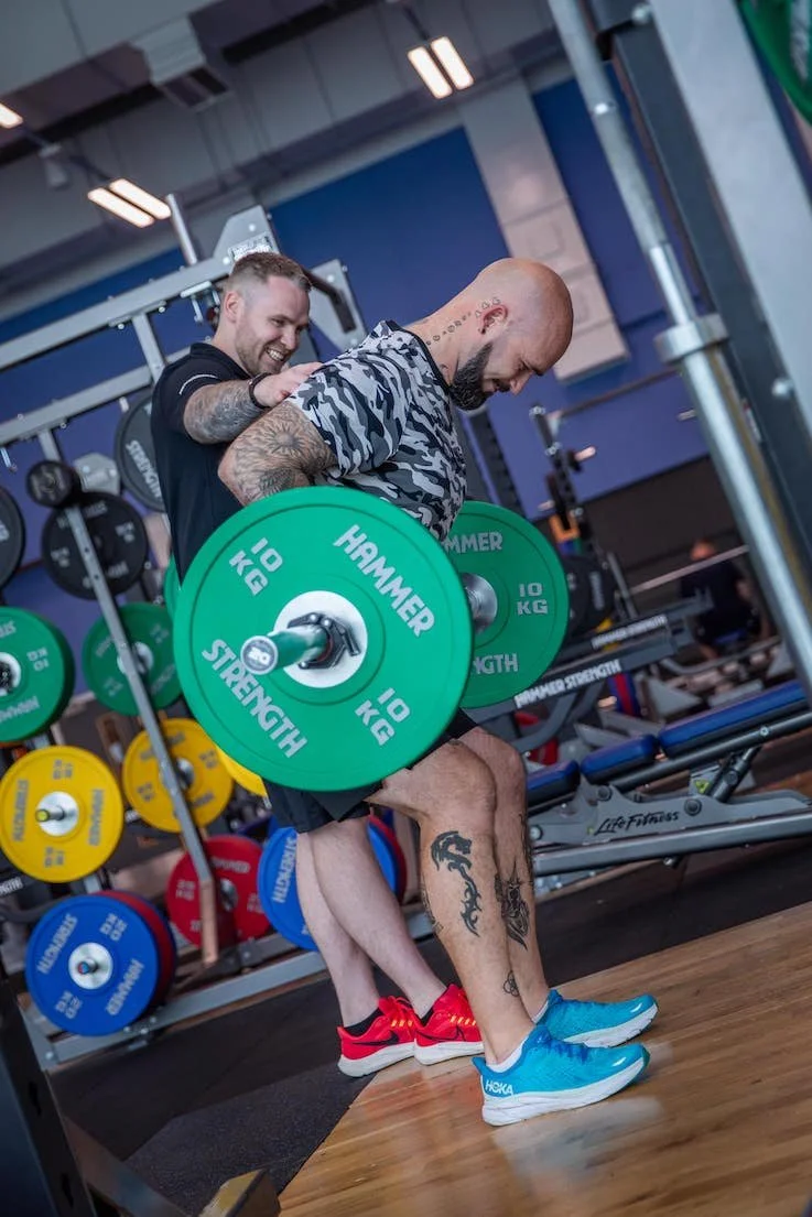 Personal trainer in Edinburgh coaching a client doing a bent over row at Meadowbank Sports Centre