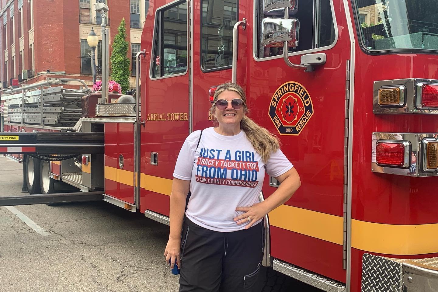 Tracey Tackett stands next to a red Springfield Ohio fire and rescue truck.