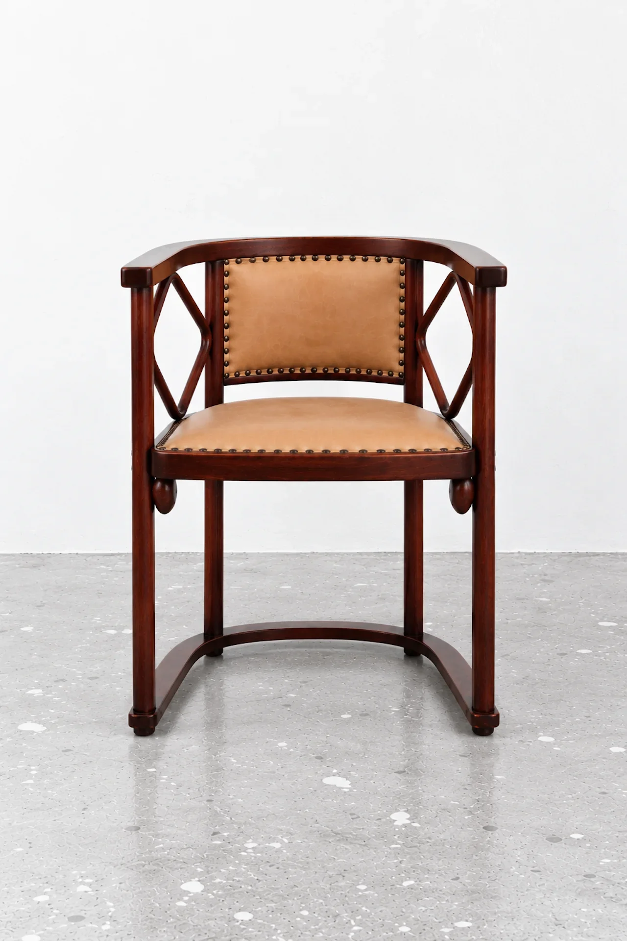 Symmetrischer Mahagoni-Sessel mit Lederpolsterung.webp