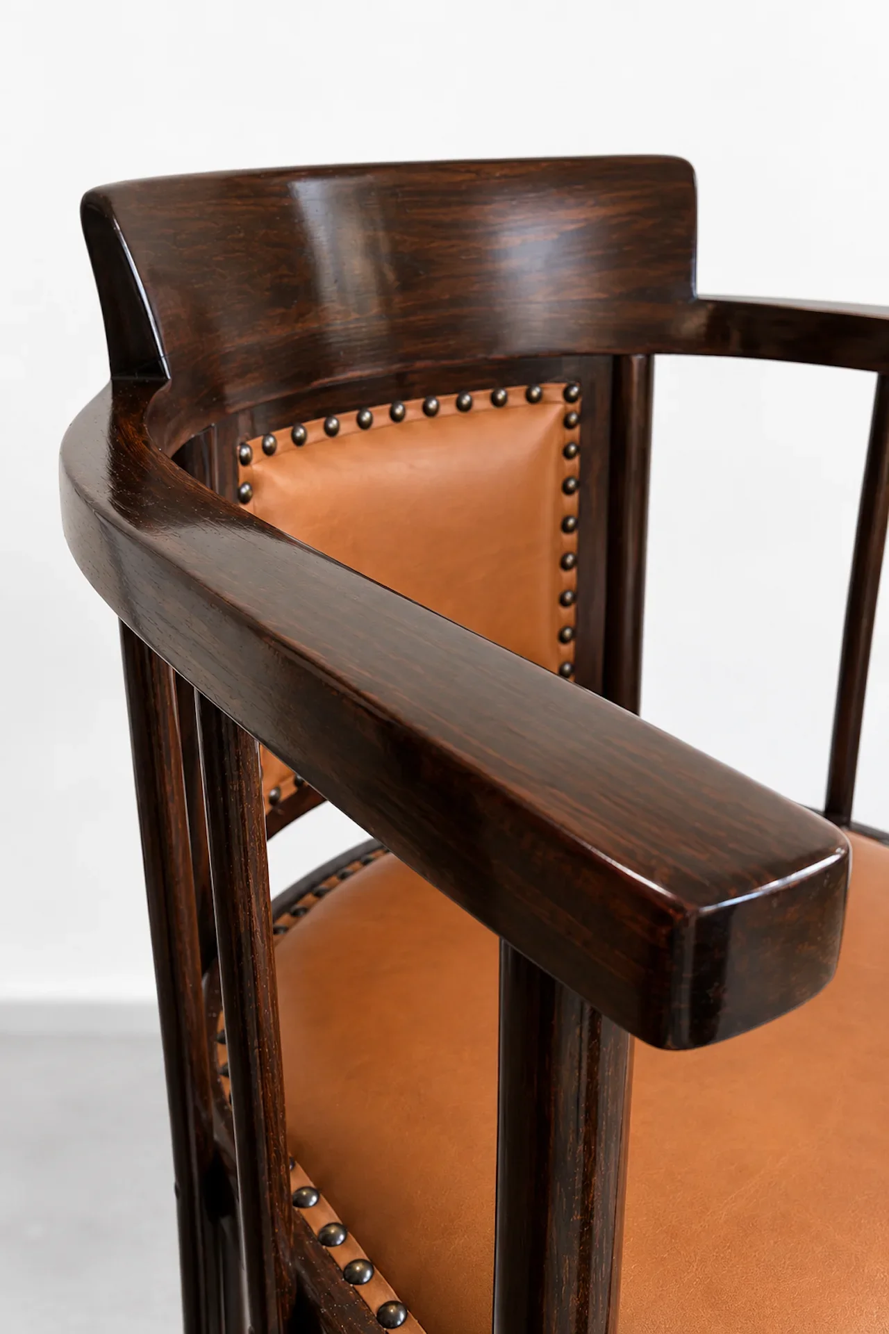 Polierter Holzstuhl mit Cognacleder.webp