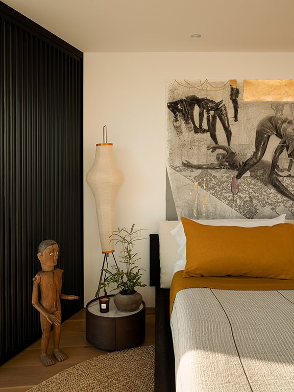  One of the primary bedrooms includes a work by Cosmo Whyte above the custom made bed and an Indonesian Toraja Tau Tau and ancestor figure.    Elizabeth Carababas   