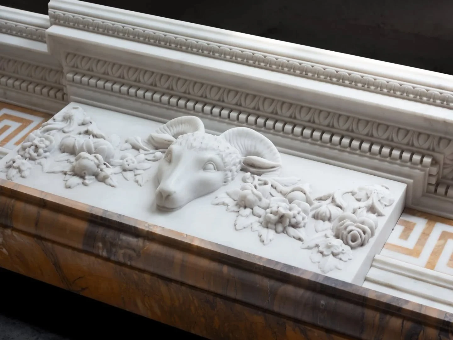 Friday nights in the workshop always feel a little special this mantel is moments away from leaving us still dusted with marble powder still holding the quiet of the space where it was carved the ram slowly emerging from stone surrounded by fruit and