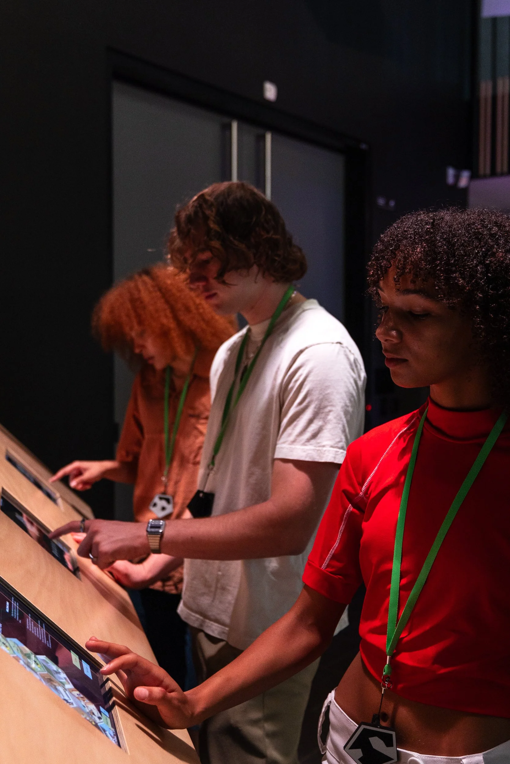 group of young visitors interact with the exhibition digital screens