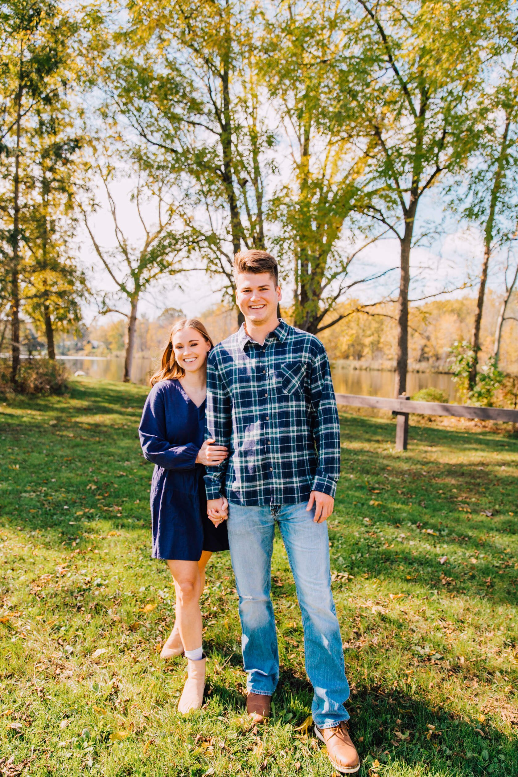  engaged couple smile hand in hand at fall mini sessions 