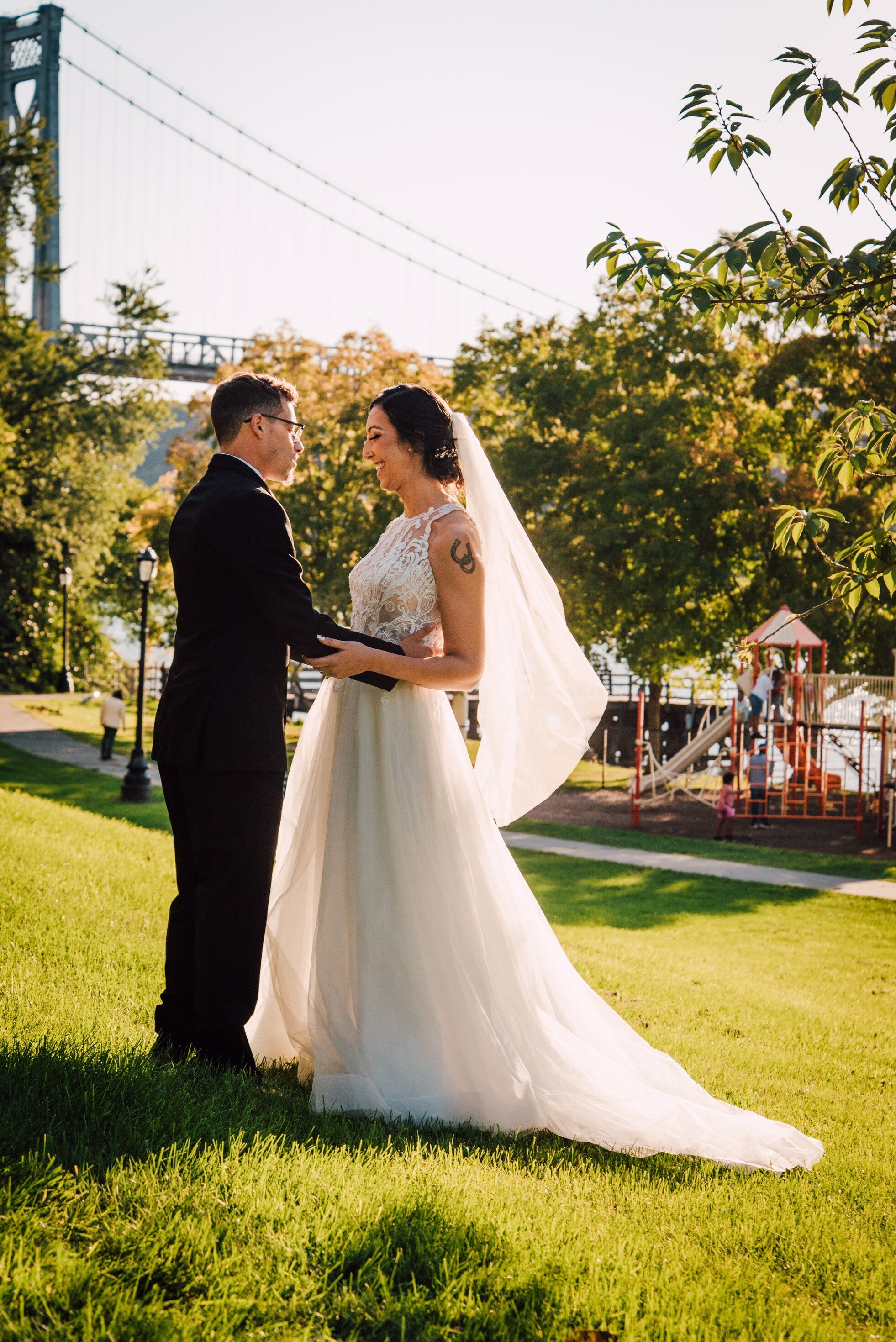  the bride and groom share a smile and embrace at their hudson river wedding first look 