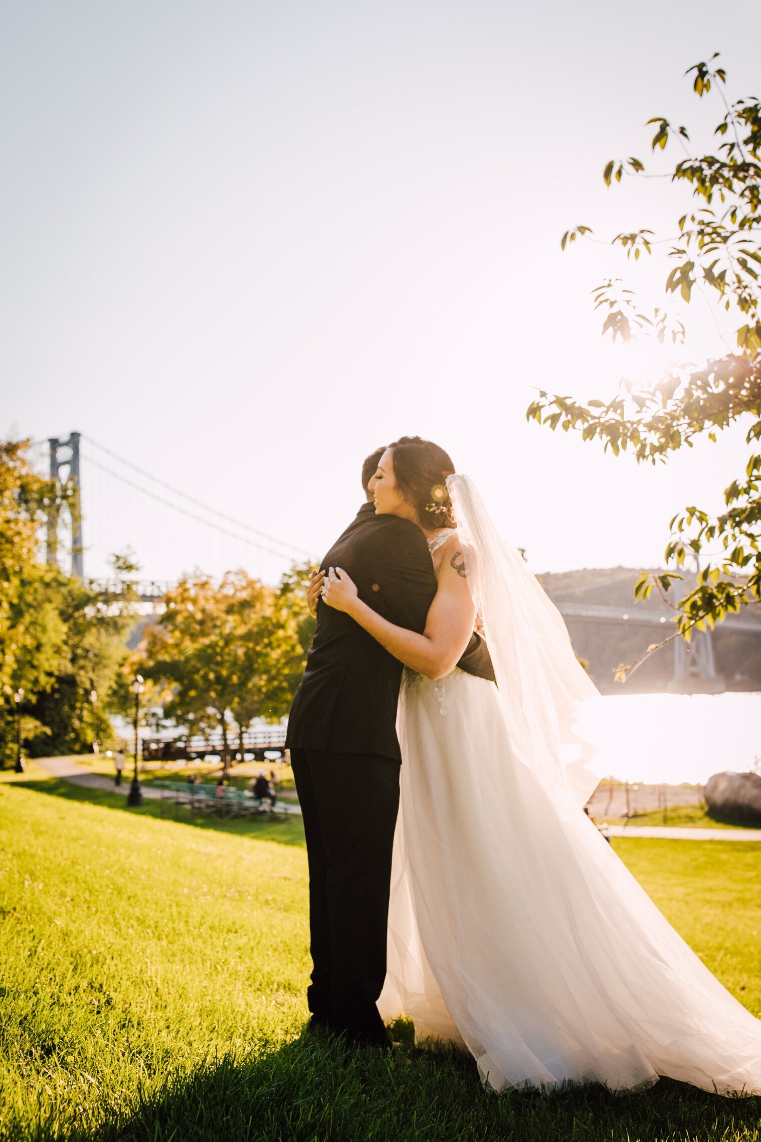  the couple share a hug before their hudson river wedding 